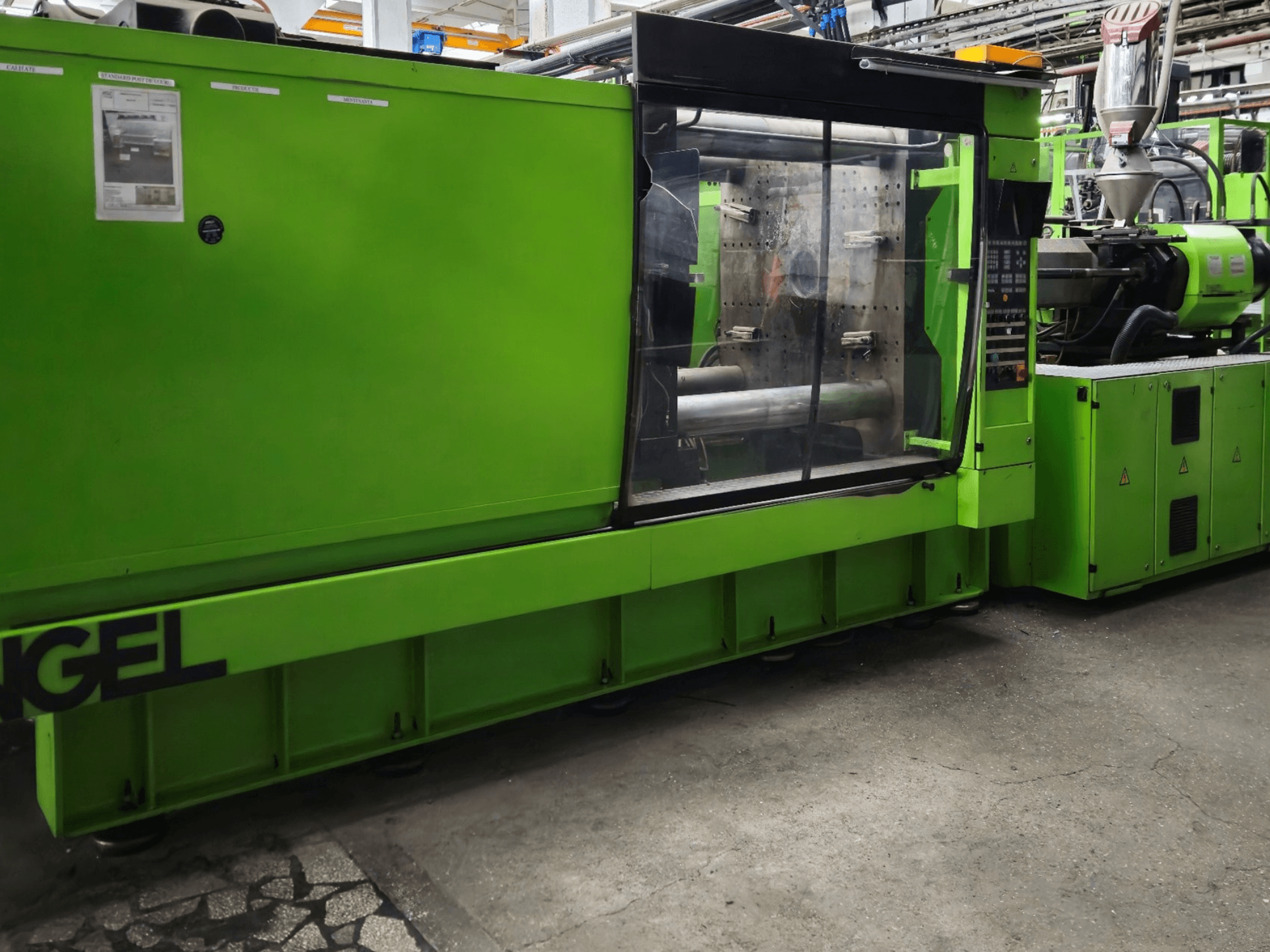 Green Engel injection molding machine, side view, features control panel and large viewing window.