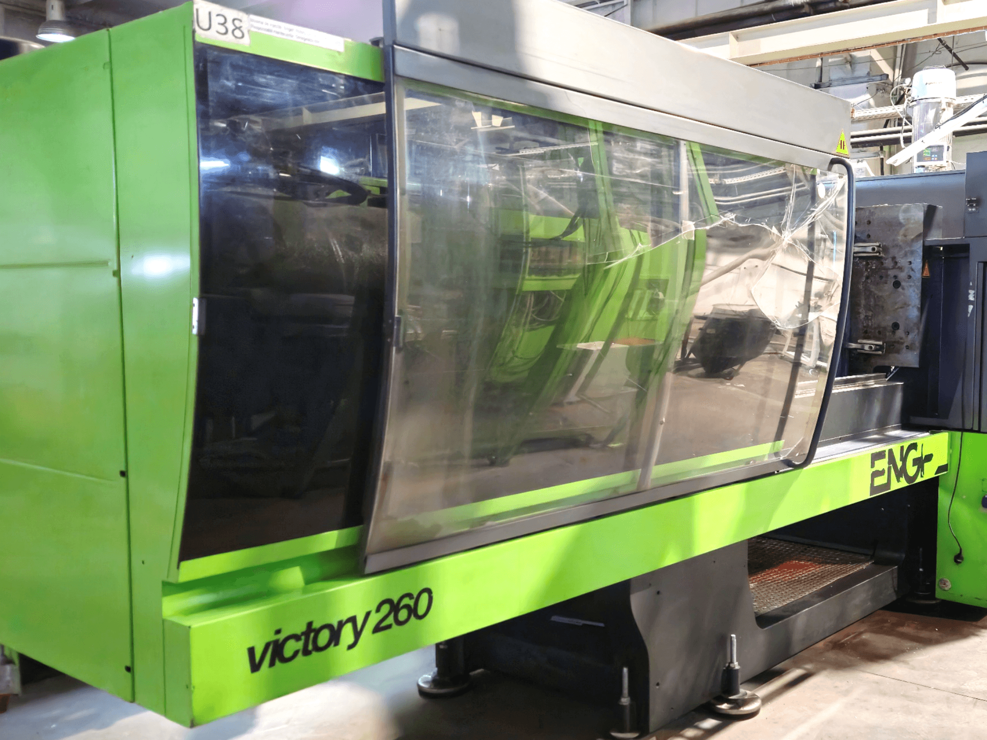 Máquina de moldeo por inyección ENG victory 260, vista frontal; presenta un exterior verde y un gran panel de cristal para mayor visibilidad.