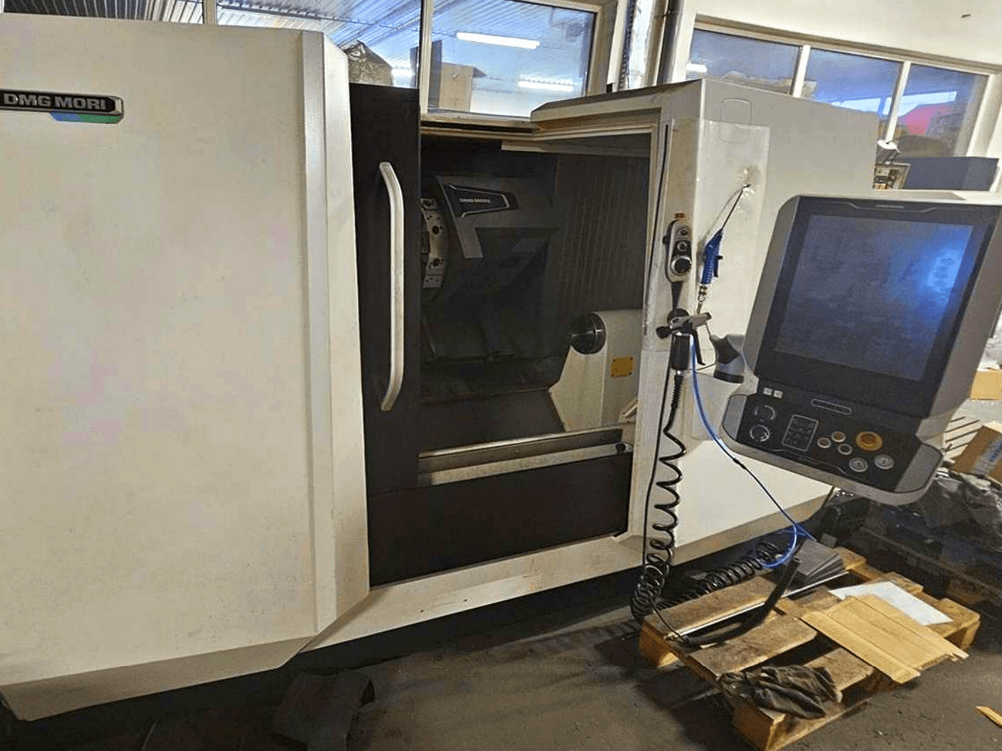 DMG MORI CLX 450 V4 máquina de torneado horizontal, vista frontal con panel de control, mostrando el espacio de trabajo y el diseño del cuerpo.