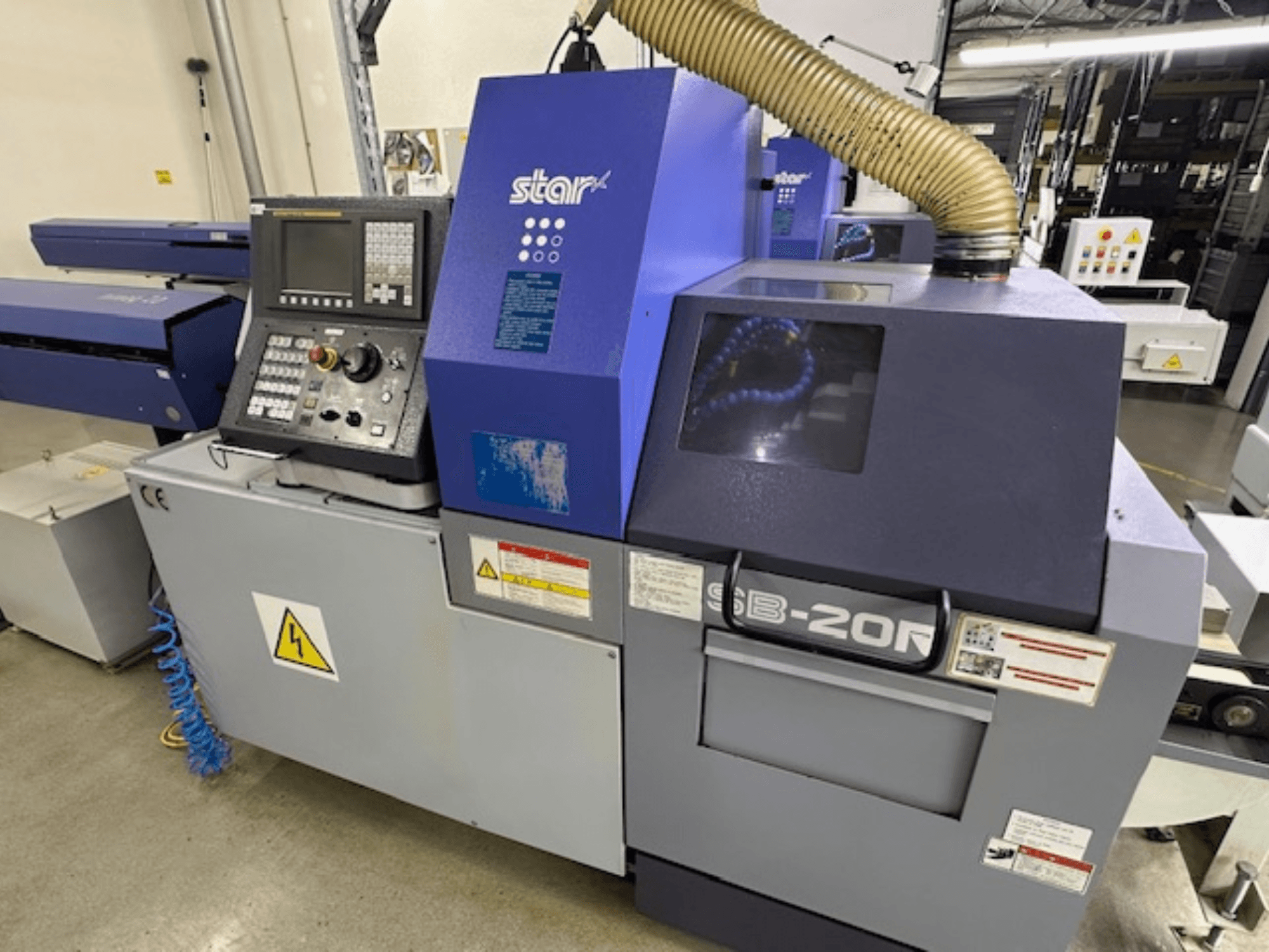 Máquina giratoria suiza Star SB-20R tipo N, vista frontal, con panel de control, manguera de aspiración y símbolos de peligro visibles.