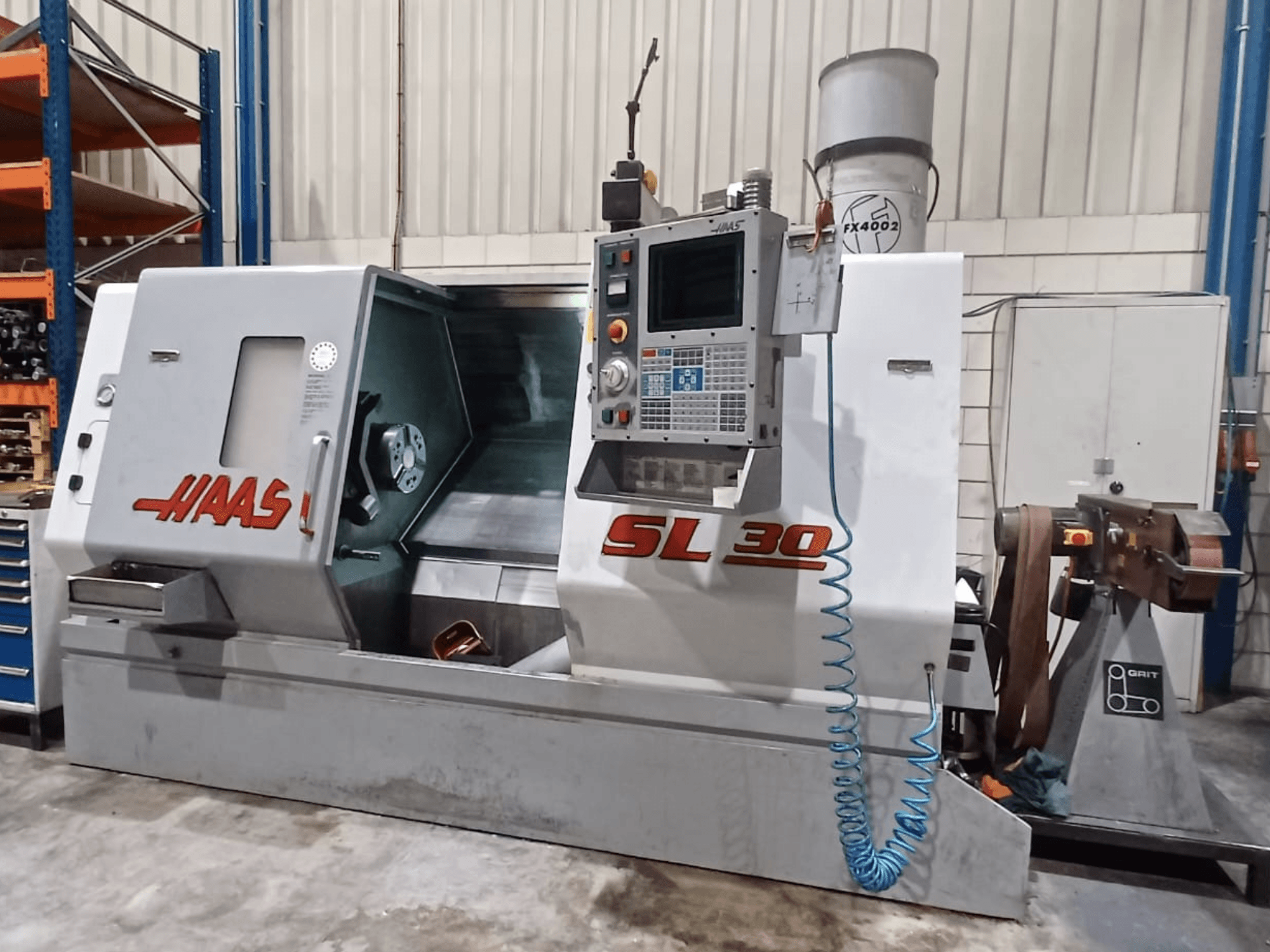 Haas SL 30 CNC lathe in side view, showcasing control panel, machining area, and coolant system integrated for metalwork.