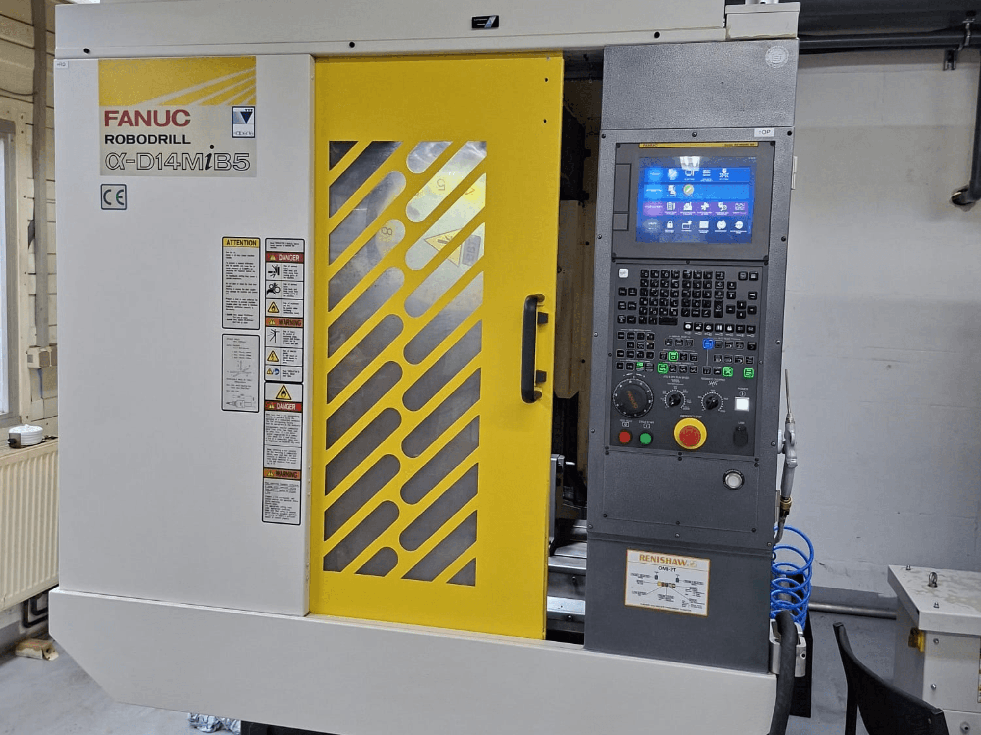 Centro de mecanizado vertical FANUC ROBODRILL α-D14MiB5, vista frontal mostrando panel de control y características de seguridad con acentos amarillos.
