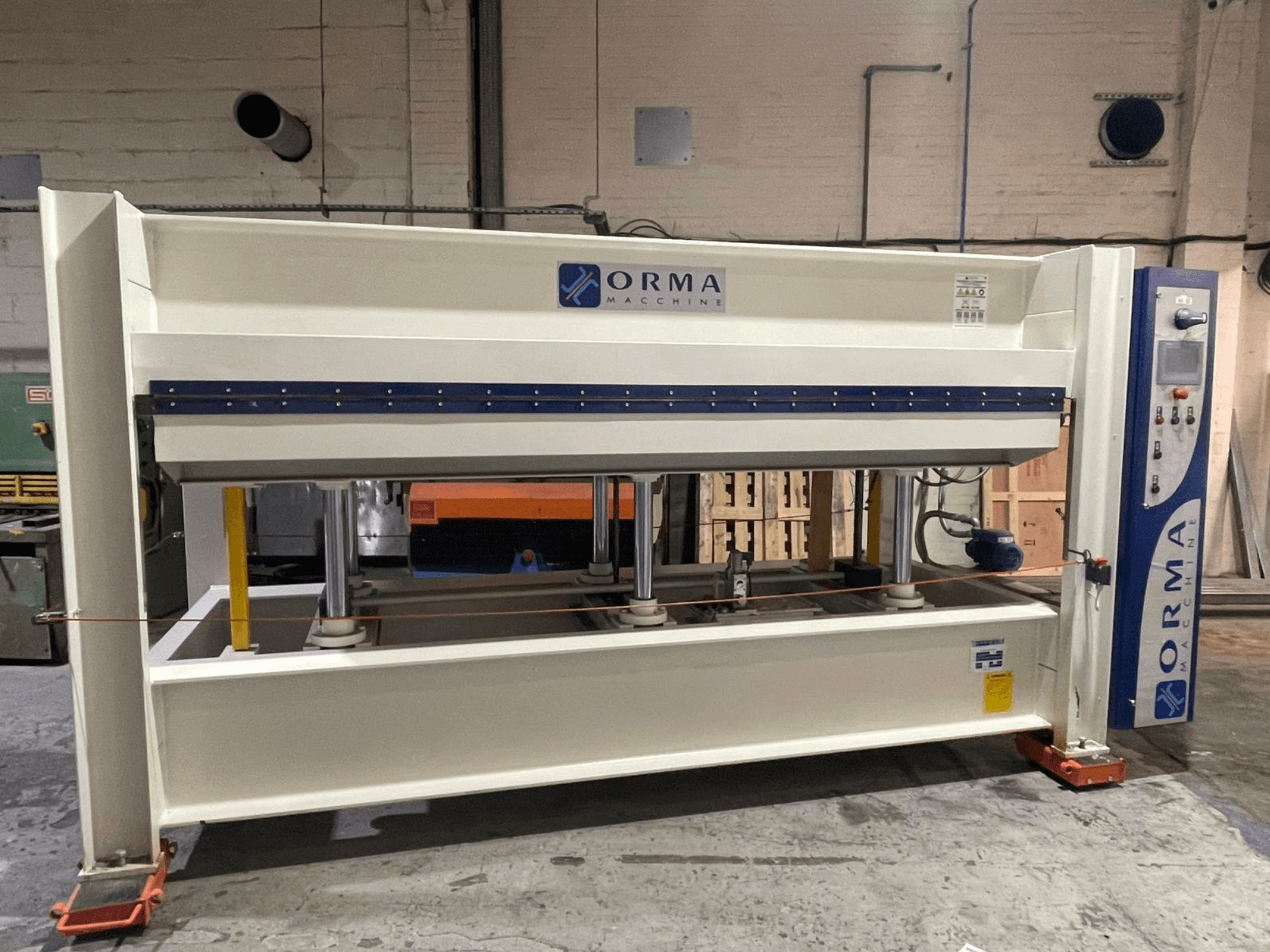 Prensa hidráulica de maquinaria ORMA, vista frontal, con acabado plateado, panel de control a la derecha y pistones verticales para prensar.