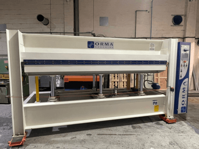 Prensa hidráulica de maquinaria ORMA, vista frontal, con acabado plateado, panel de control a la derecha y pistones verticales para prensar.