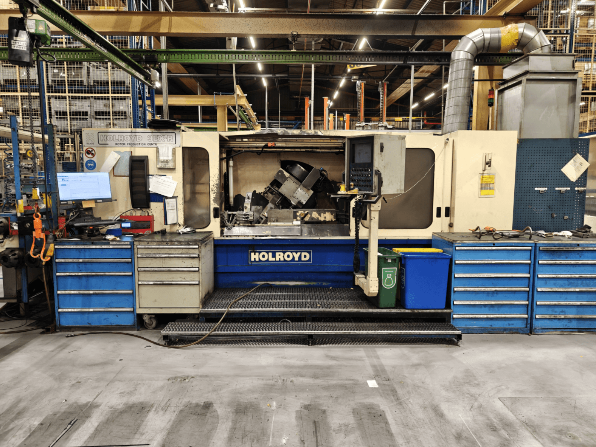 Máquina herramienta Holroyd 3EX-R en un taller, vista frontal, mostrando el panel de control, el almacenamiento de herramientas y el área de trabajo en el interior.