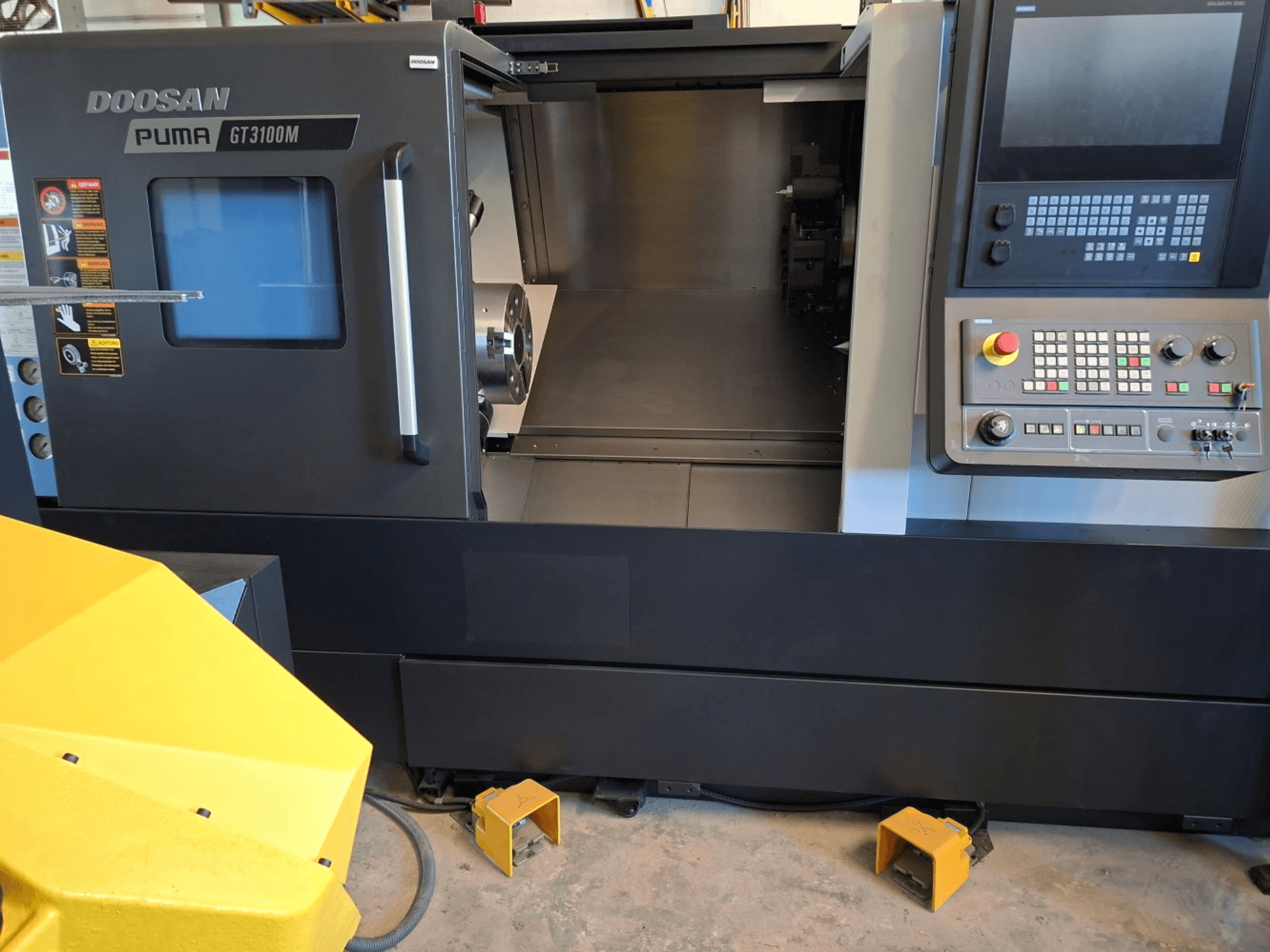 Tornos horizontales DOOSAN Puma GT 3100 M en vista frontal, mostrando el panel de control, la torreta abierta y el espacio de trabajo interior.