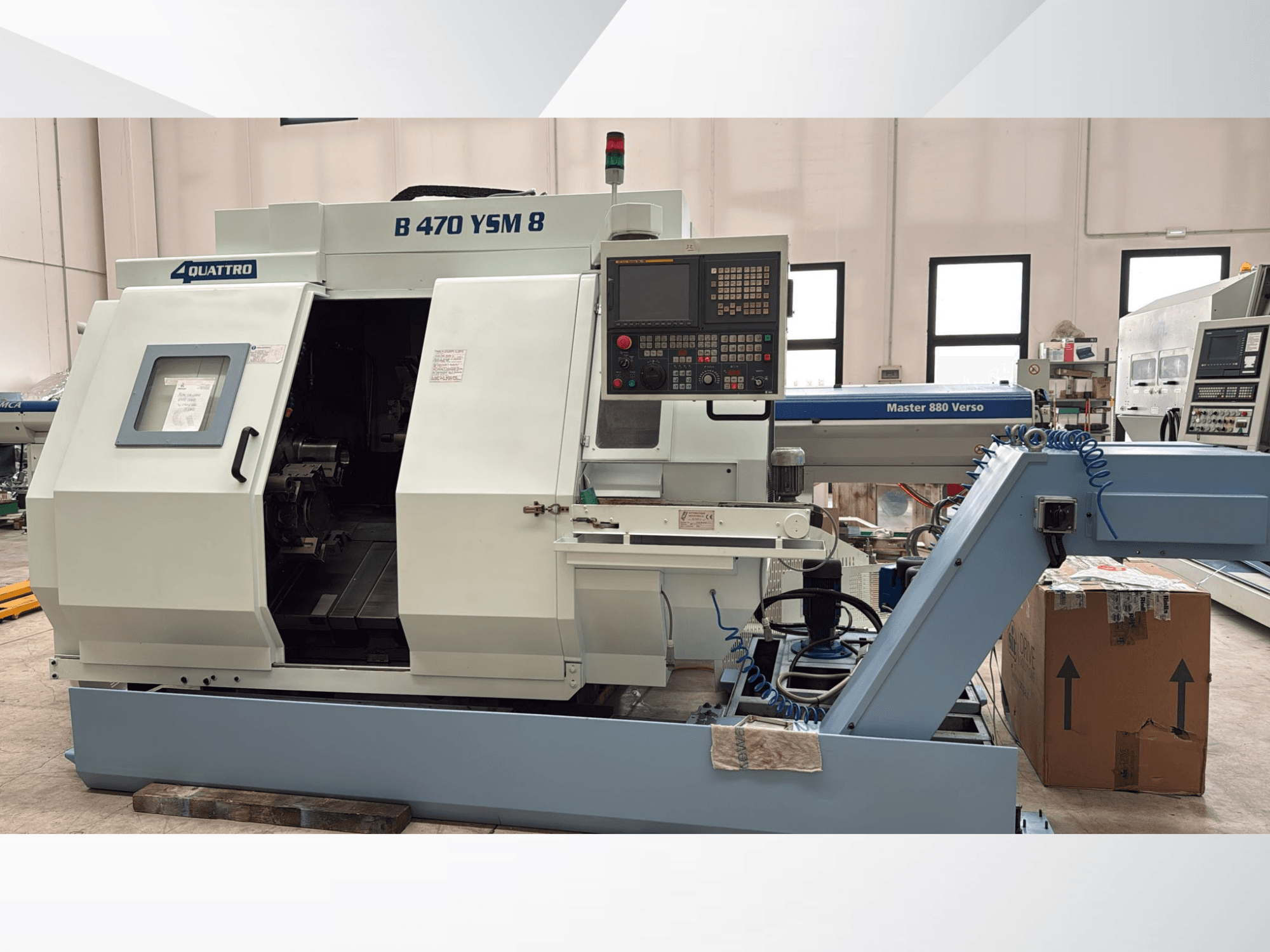 Centro de torneado y fresado Biglia B470 YSM, vista frontal que muestra el panel de control, la escotilla abierta y el espacio de trabajo con las herramientas en el interior.