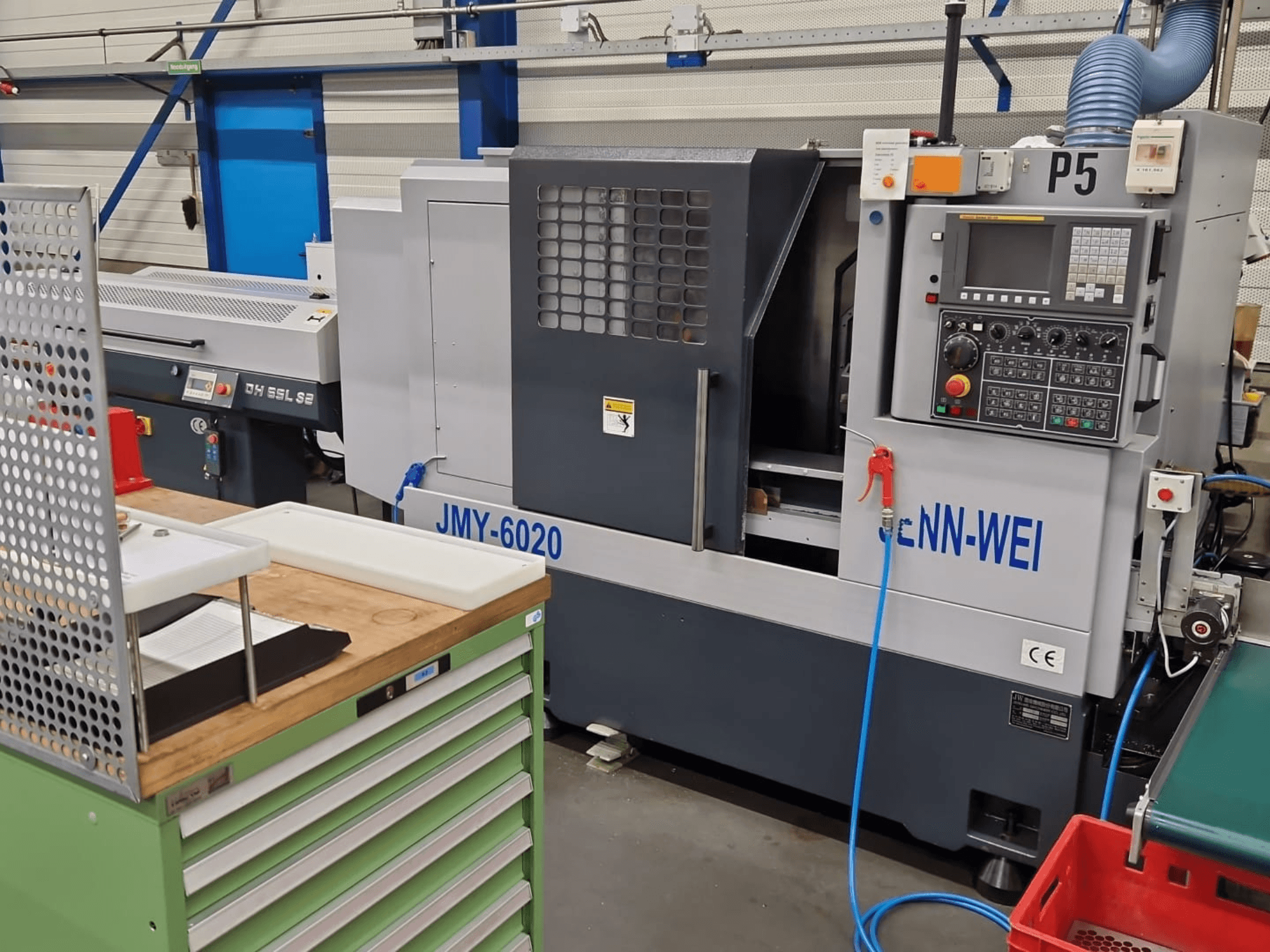 Torno CNC, modelo JMY-6020 de cNN-WEI, visto de frente. Incluye panel de control, parada de emergencia y conducto de refrigerante.