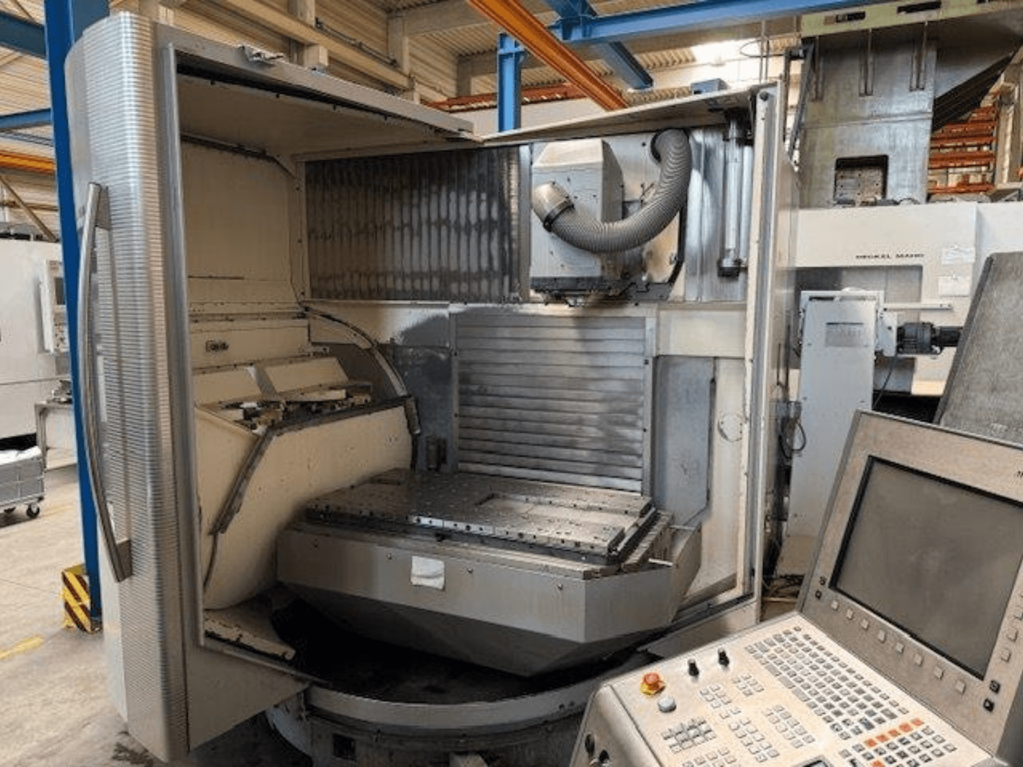 Centro de mecanizado vertical DMG MORI DMU 80T, vista frontal mostrando la carcasa abierta y el panel de control.