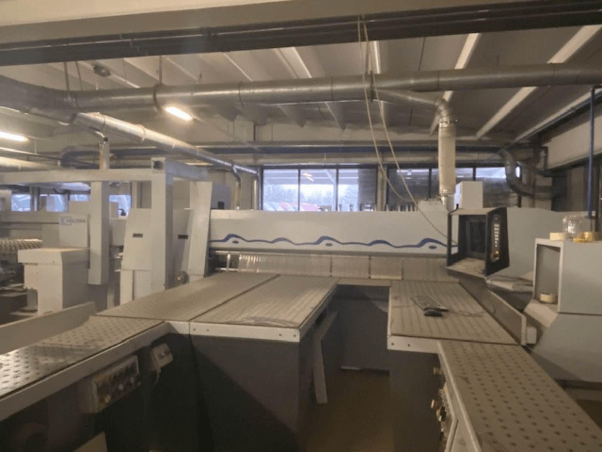 Espacio de trabajo industrial con una instalación de maquinaria con panel de control, vista desde un ángulo frontal elevado.