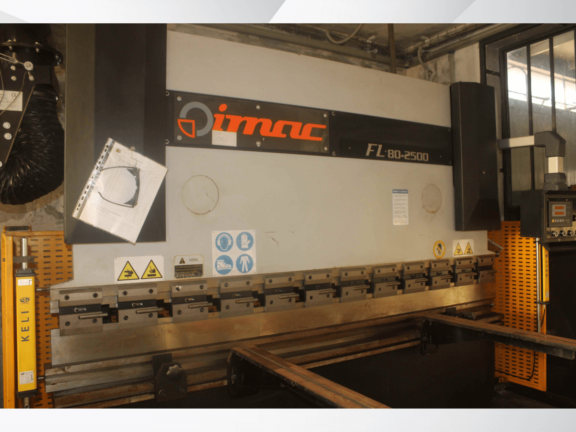 IMAC FL 80-2500 bending machine, front view, featuring control panel, safety warnings, and metal tooling components.