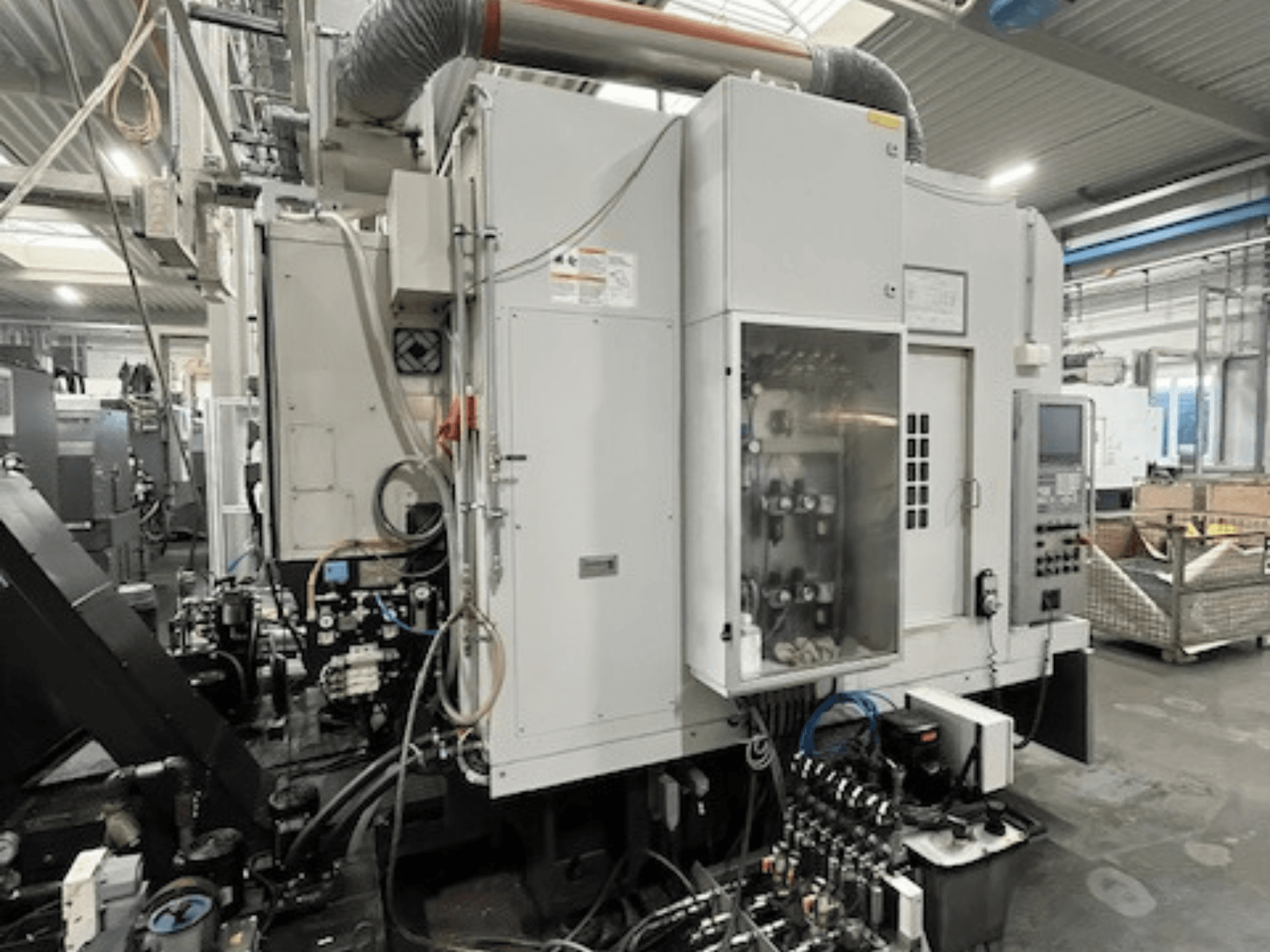 Vista lateral de máquina industrial con panel de control y componentes hidráulicos, mostrando detalles de la marca y el modelo.