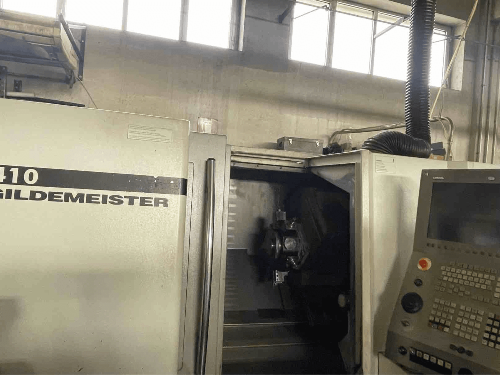 DMG CTX410 torno horizontal, vista frontal, mostrando el panel de control y los componentes de mecanizado visibles en el interior.