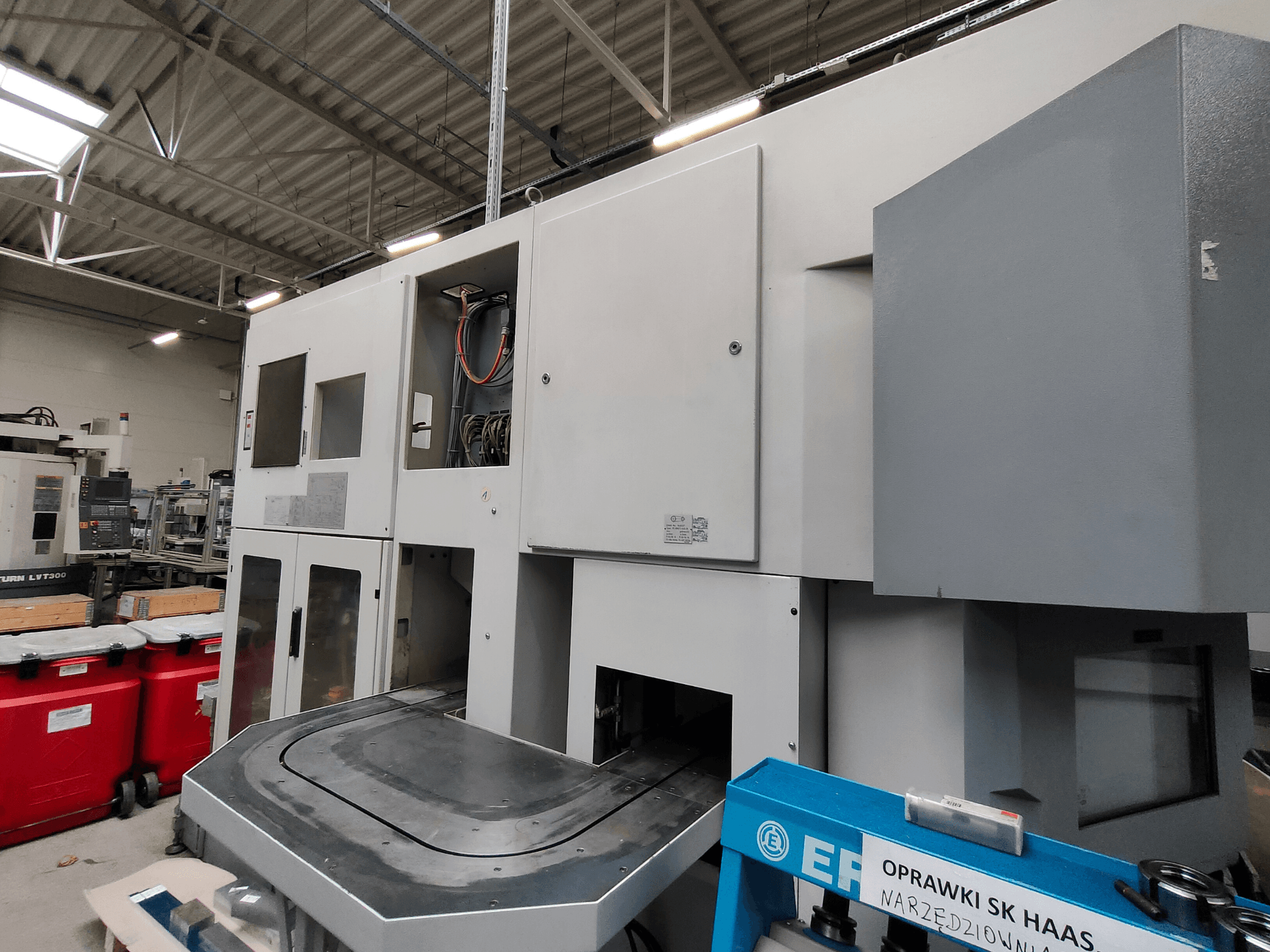 Máquina de torneado vertical EMAG VSC 250 mostrada lateralmente, con paneles de control y una amplia zona de trabajo.