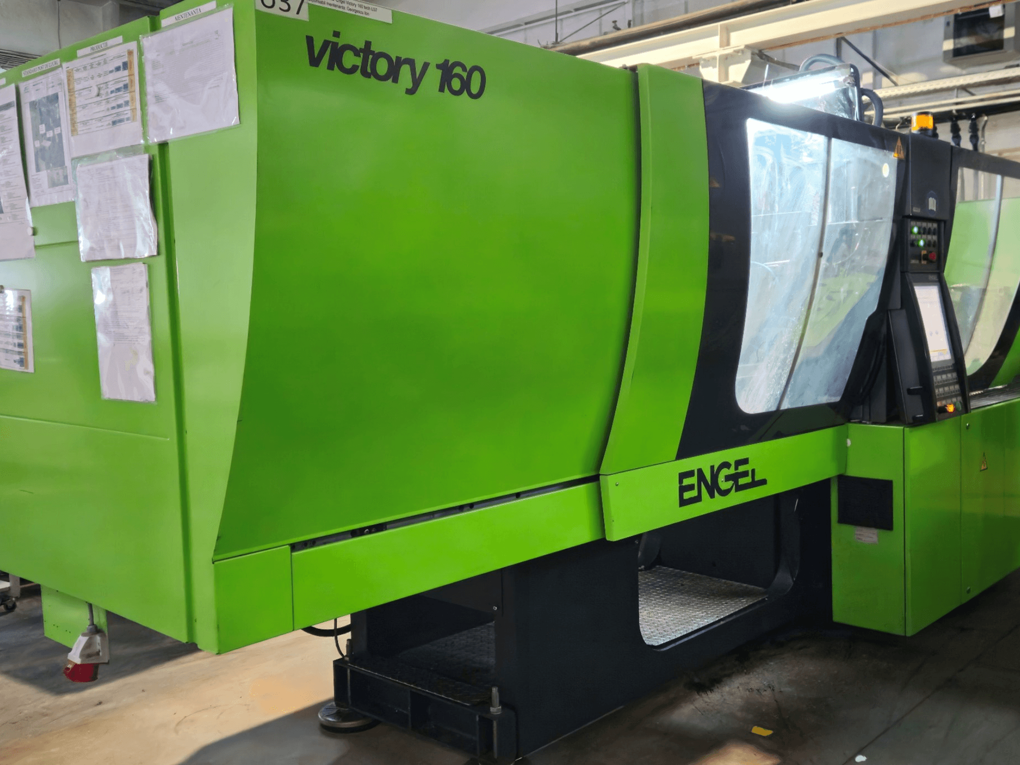 Verde ENGEL Victory 160 máquina de moldeo por inyección, vista lateral, con panel de control, luces de seguridad, y la documentación operativa.