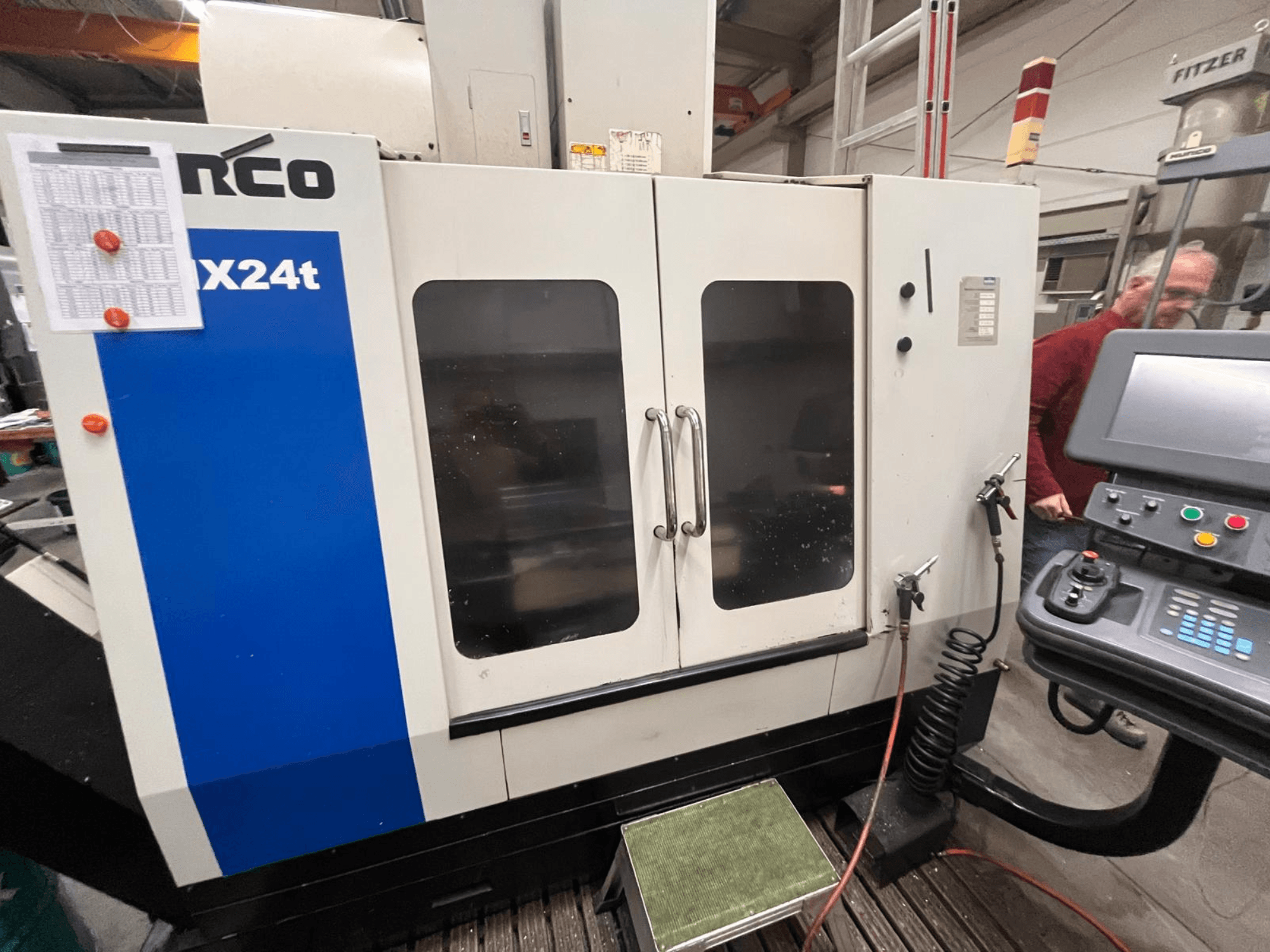 Centro de mecanizado vertical de Hurco, modelo VX24t, mostrado de frente con panel de control y puertas transparentes.