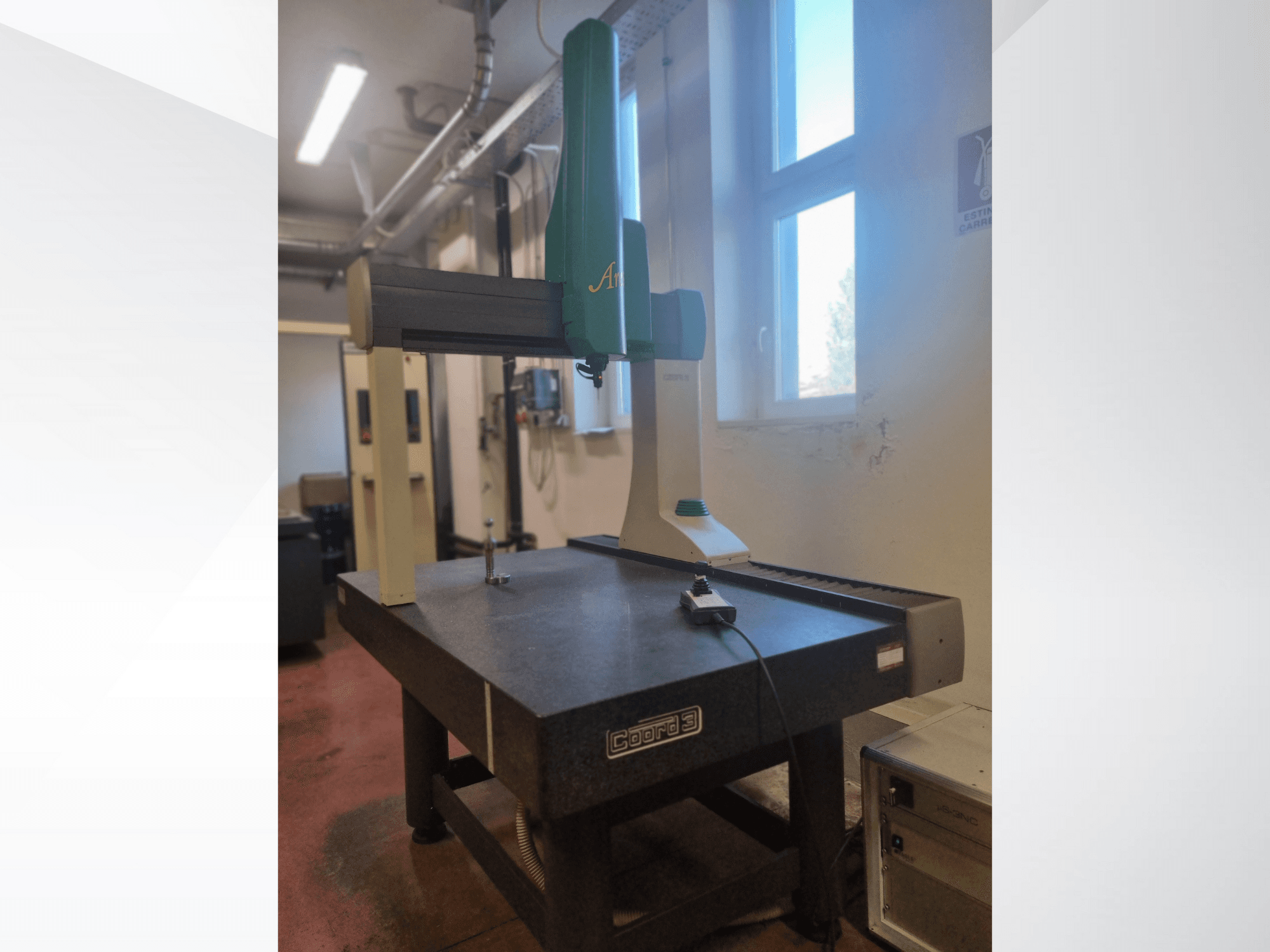 Escáner 3D GOM Atos desde una vista frontal sobre una mesa de medición de granito, con cable y dispositivo de control visibles.