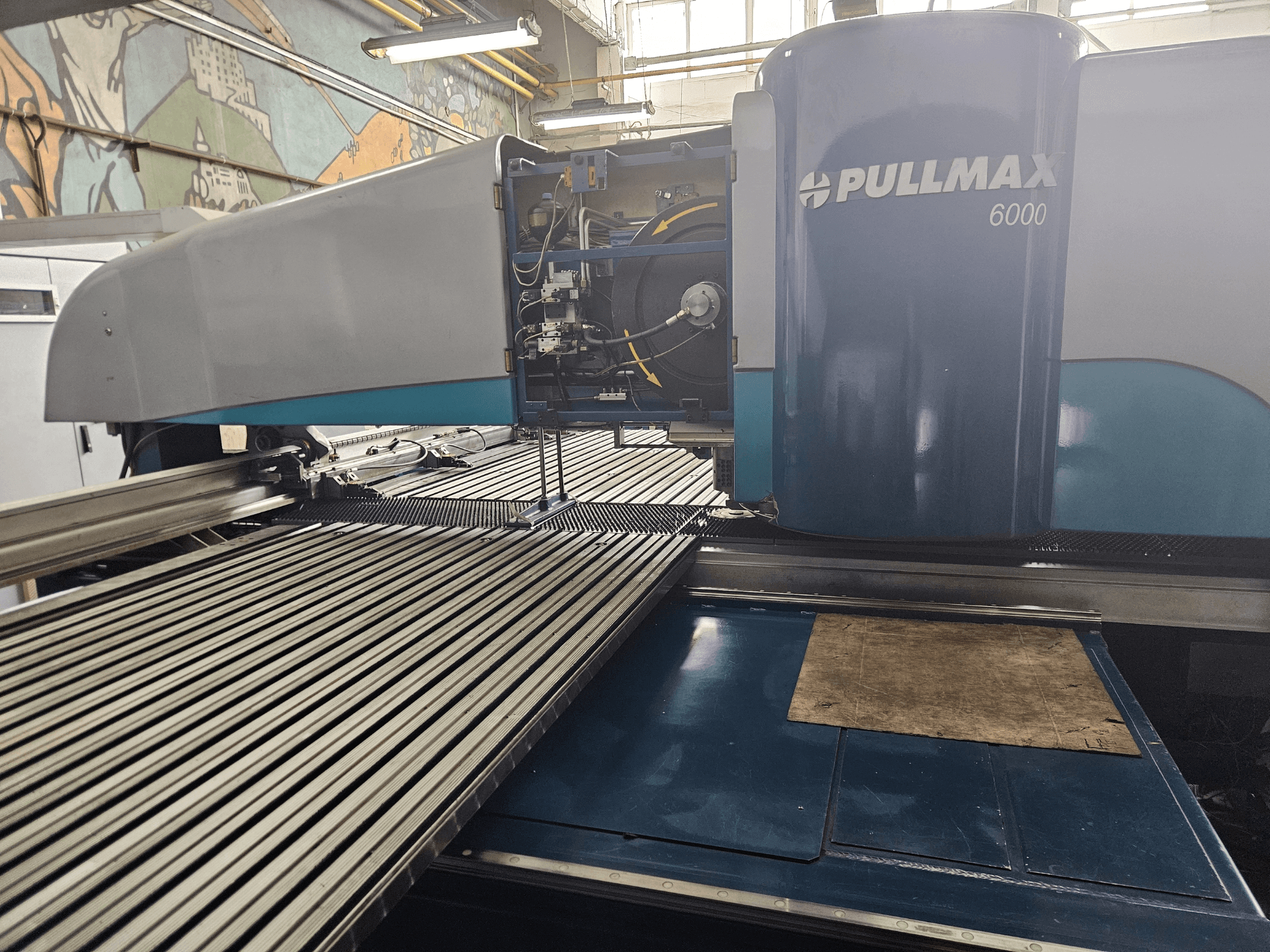 Vista frontal de una punzonadora CNC Pullmax 6000, con un diseño elegante, panel operativo y superficie de trabajo metálica.