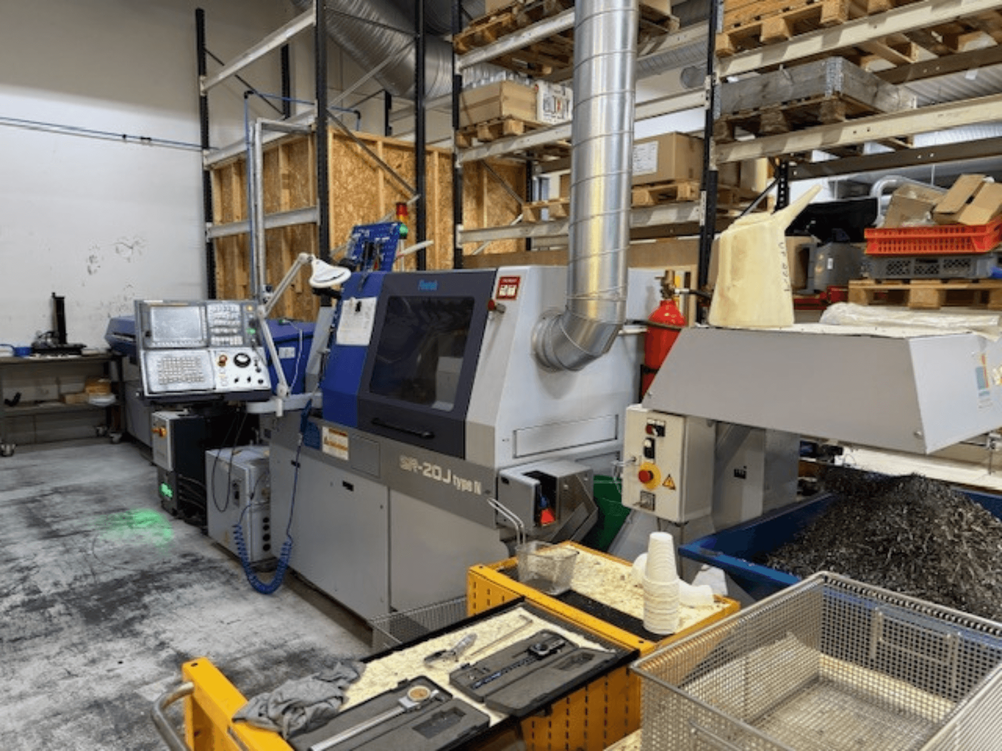 Vista frontal de un centro de mecanizado Faroh SPR-20J tipo N con panel de control, virutas de metal y equipo de seguridad en un taller.