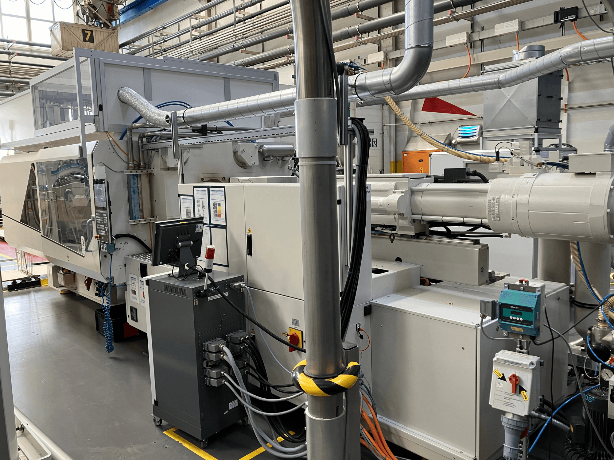 Industrial machinery with control panel, front view, featuring pipes, electrical components, and safety features.