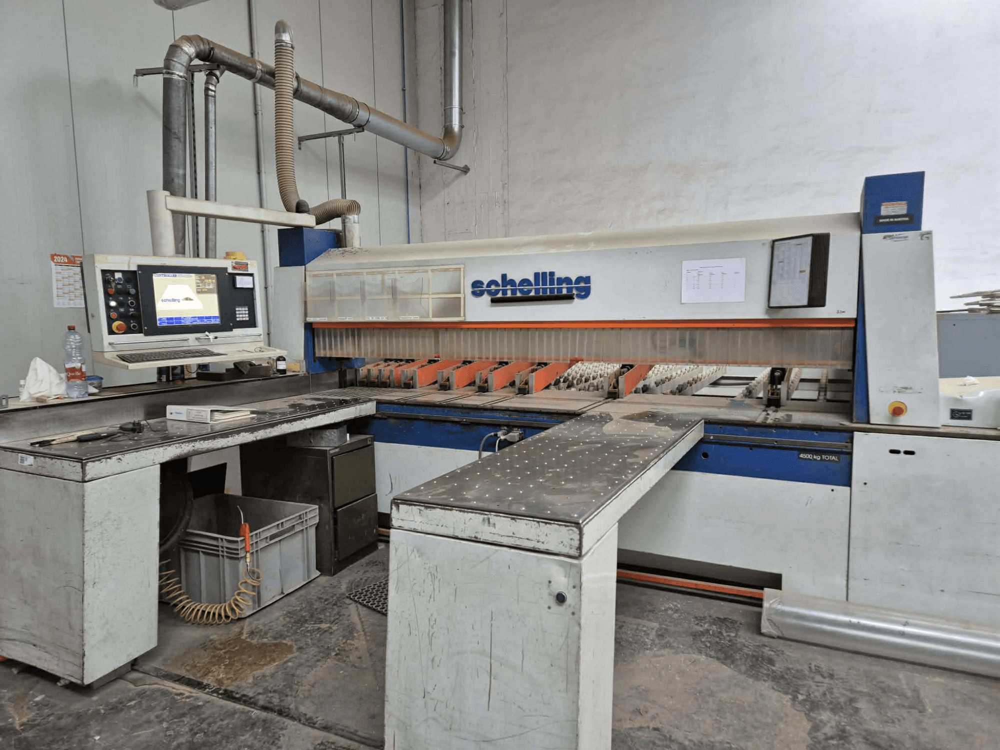 Schaublin cutting machine in side view, featuring a computer interface, sharp blades, and a sturdy metal work surface.