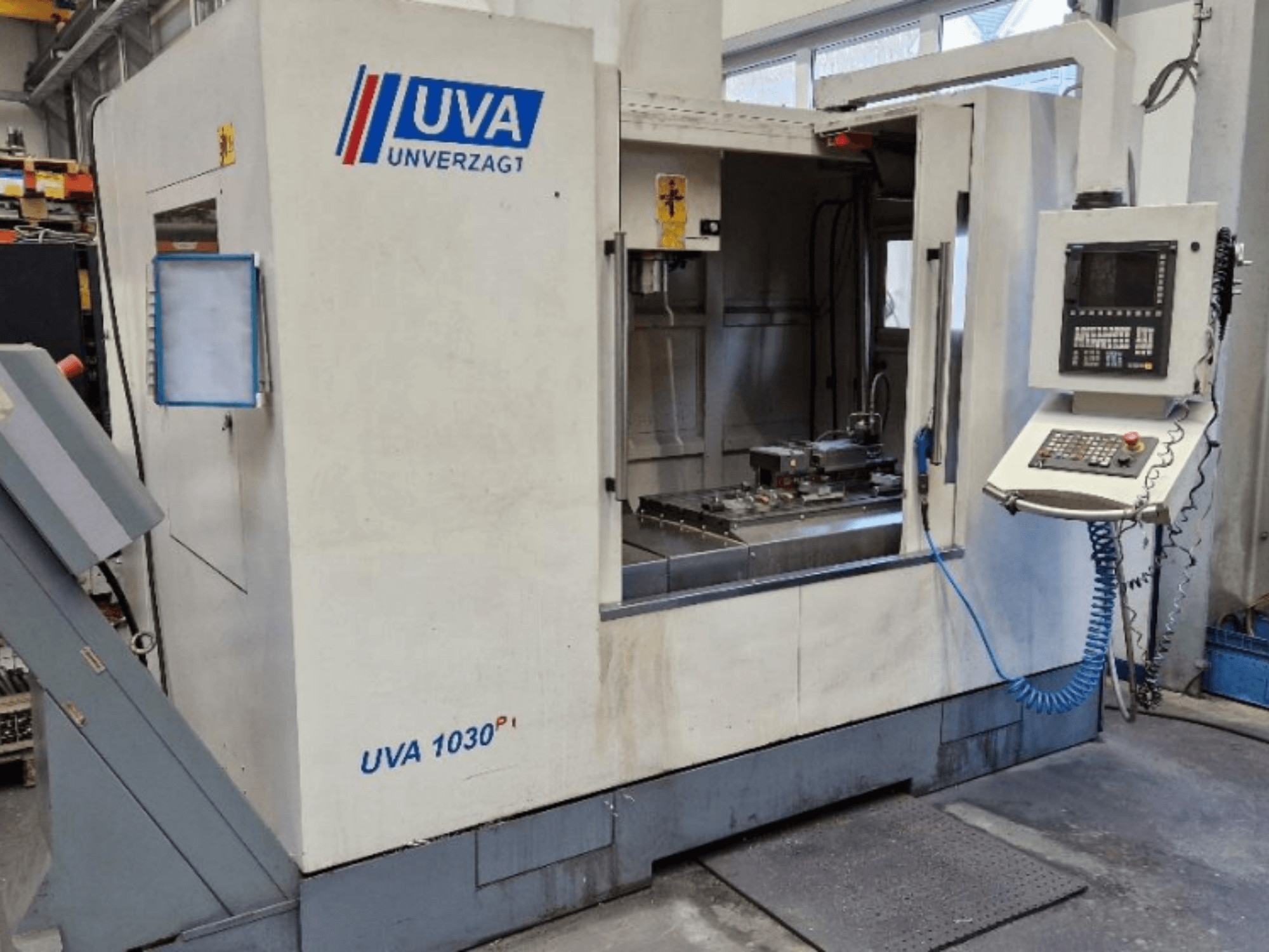 UVA 1030P machine tool in a workshop, front view showing control panel, work area, and clean cutting surface.