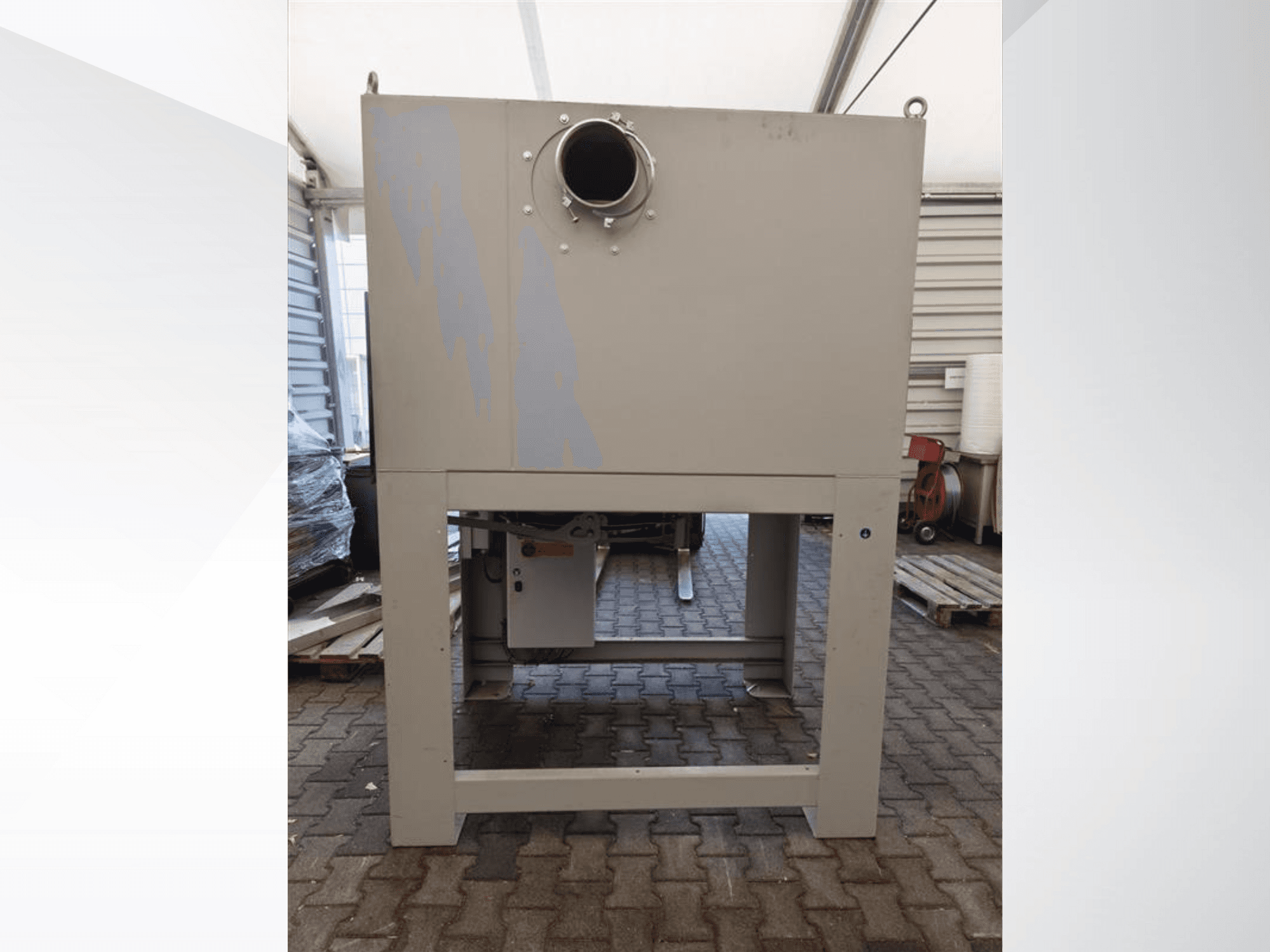 Gray industrial dust collector seen from the front, featuring a large round opening and mounted on a sturdy base.