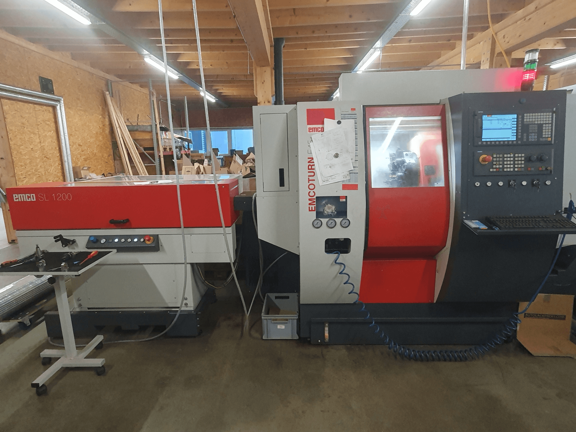 Torno CNC EMCO SL 1200 y EMCOturn; vista frontal que muestra los controles, pantallas e indicadores operativos en un entorno de taller.