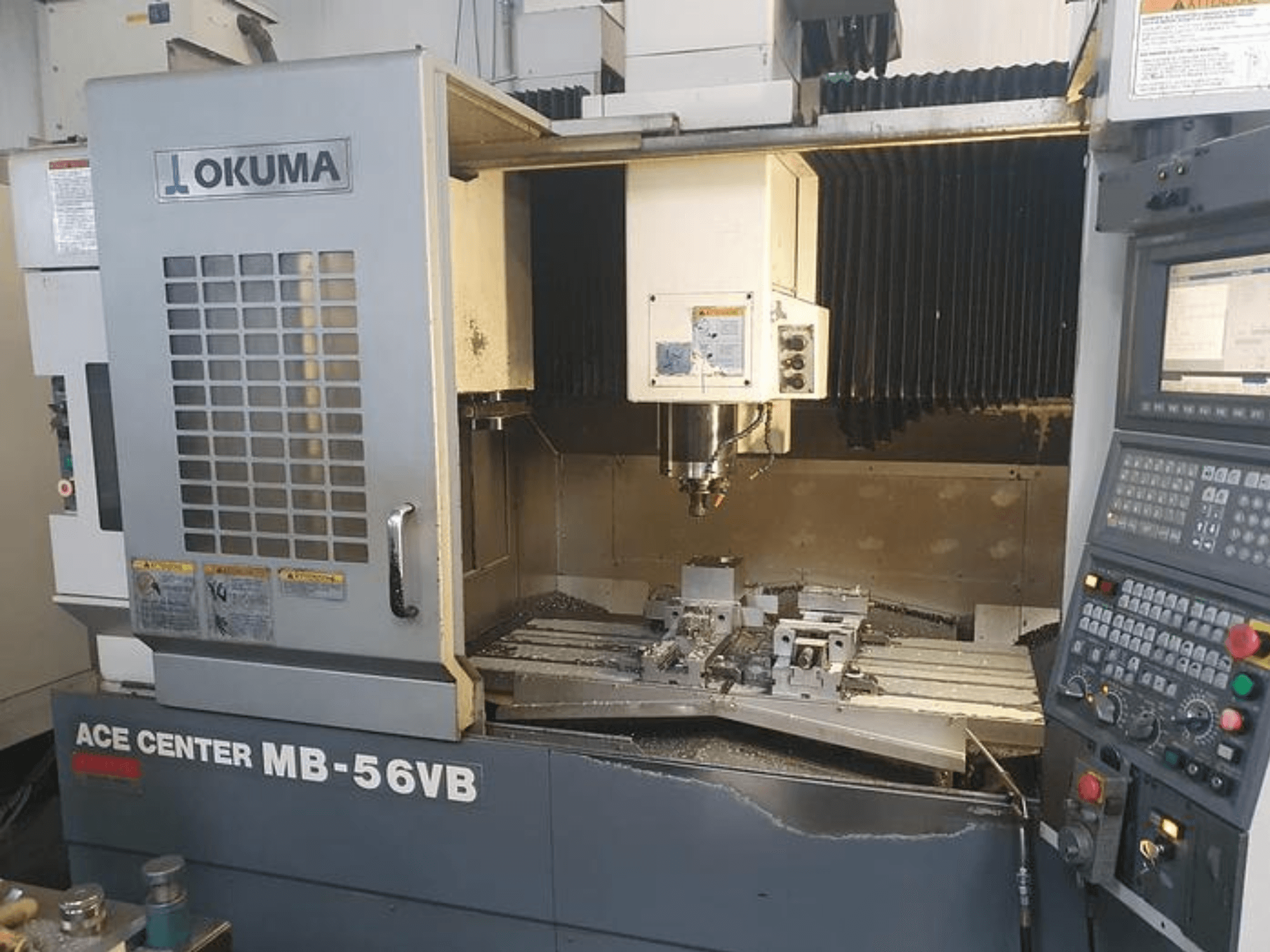 Okuma ACE CENTER MB-56VB CNC milling machine in a front view, showcasing the control panel and machining area.