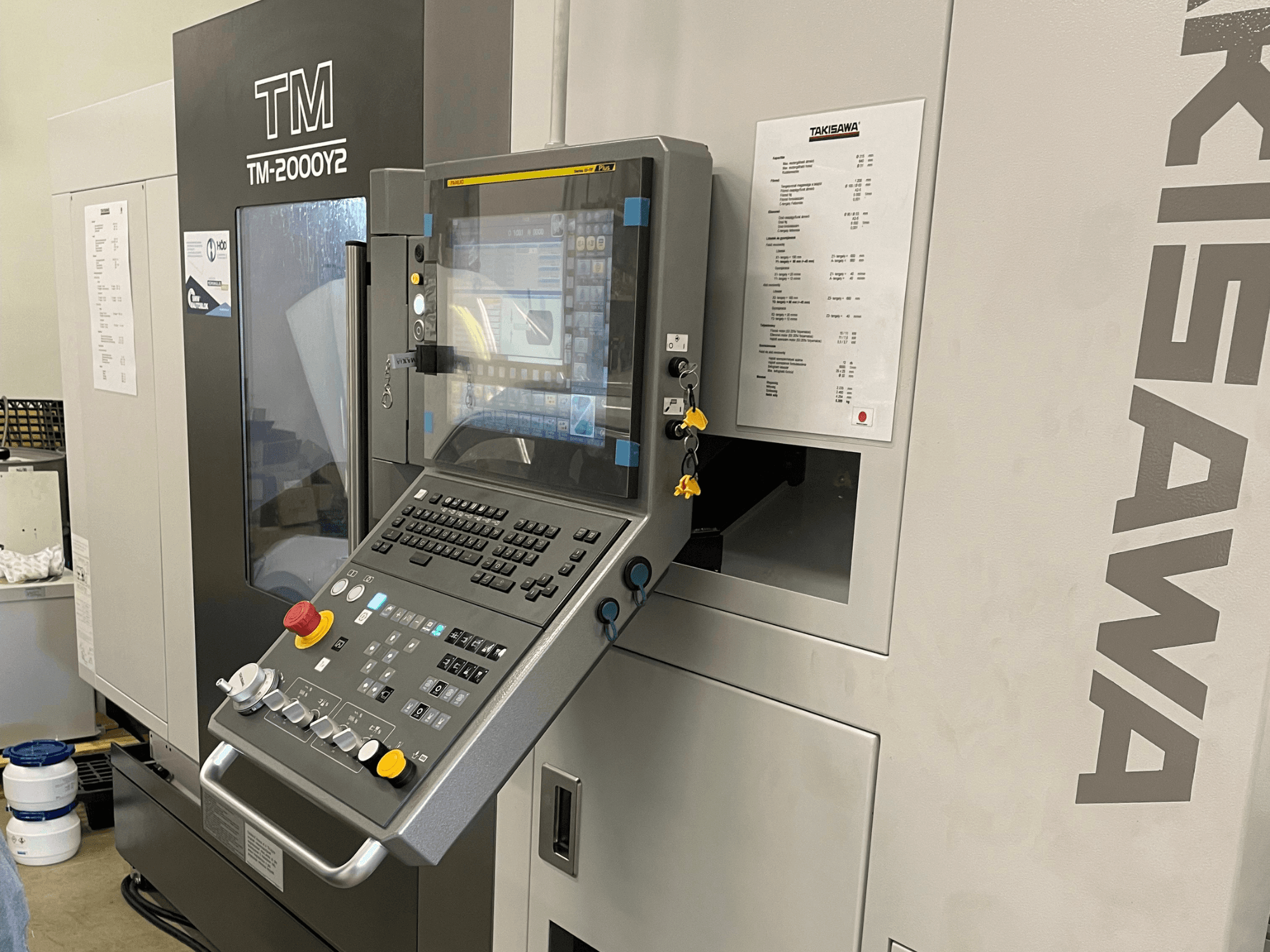 Panel de control del torno horizontal Takisawa TM-2000Y2 en vista frontal, con pantalla digital y botones de funcionamiento.