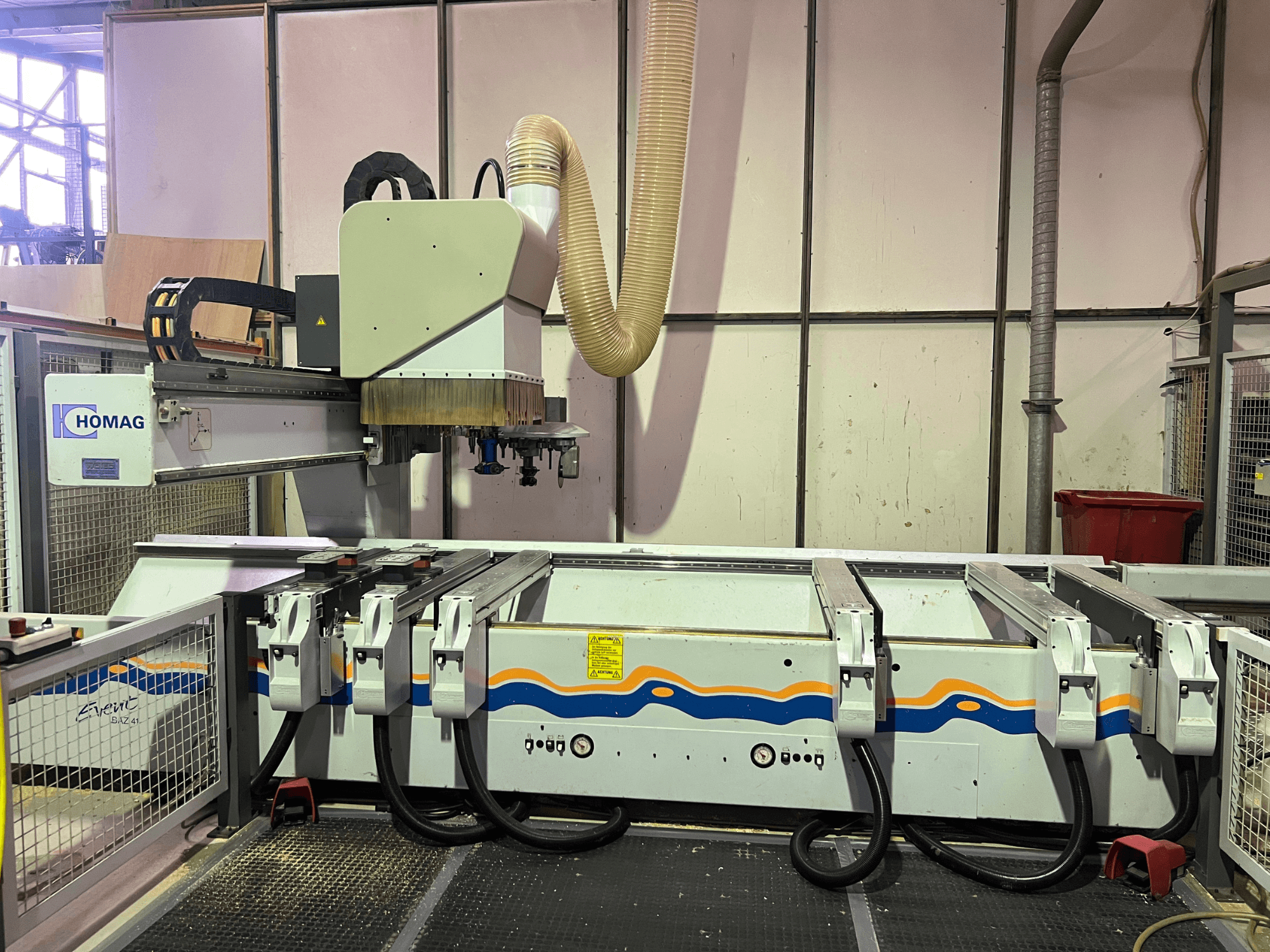 Máquina CNC HOMAG BIZ 4 en taller; vista frontal que muestra el sistema de extracción de polvo y el panel de control con cables.