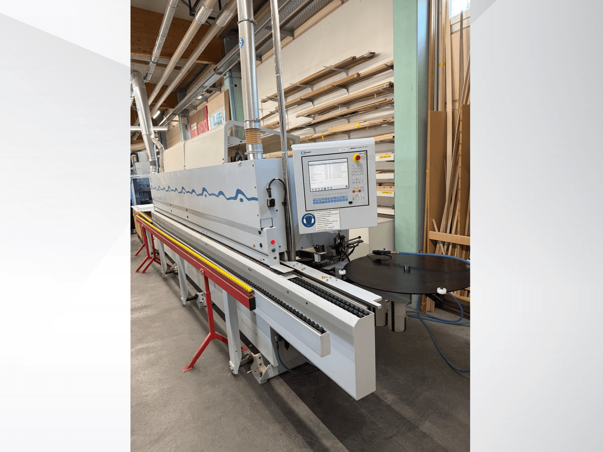 Front view of a HolzHer automatic edge banding machine with a control panel, conveying system, and round support table.