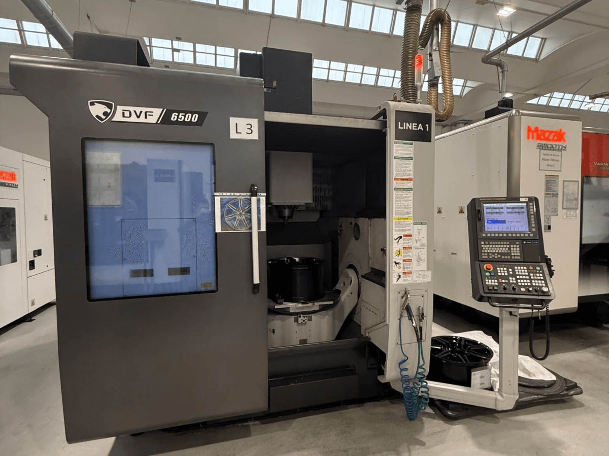 DVF 6500 CNC machine, front view, displaying control panel and interior space with a part fixture.