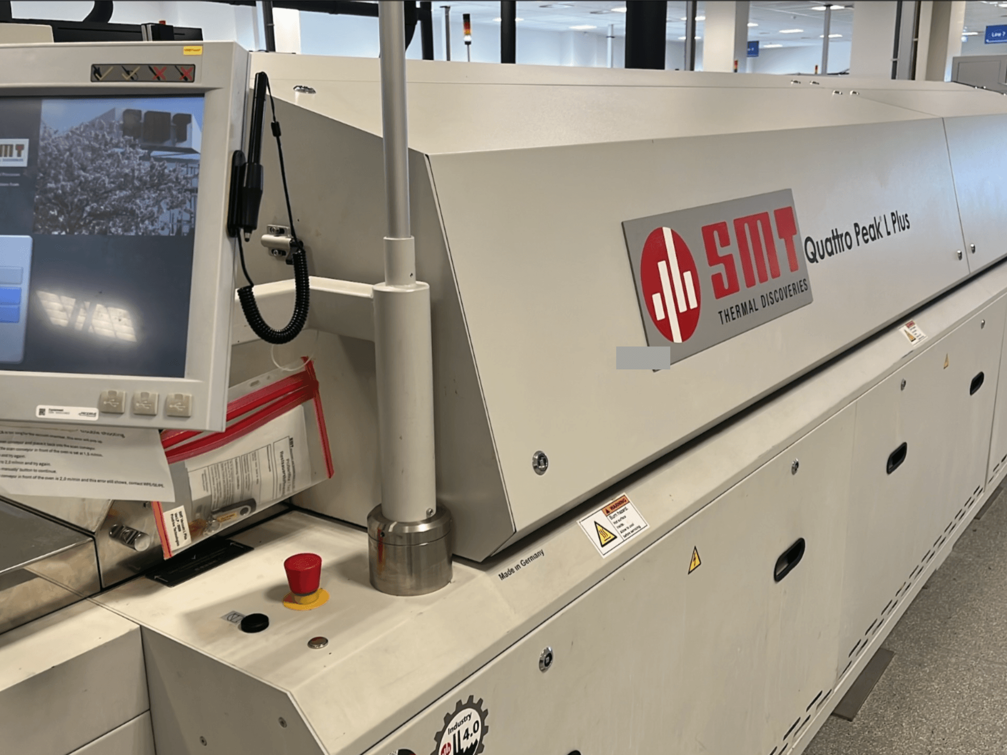 Máquina herramienta SMT Quattro Peak L Plus, vista frontal, con el panel de control, los botones de seguridad y la marca claramente visibles.