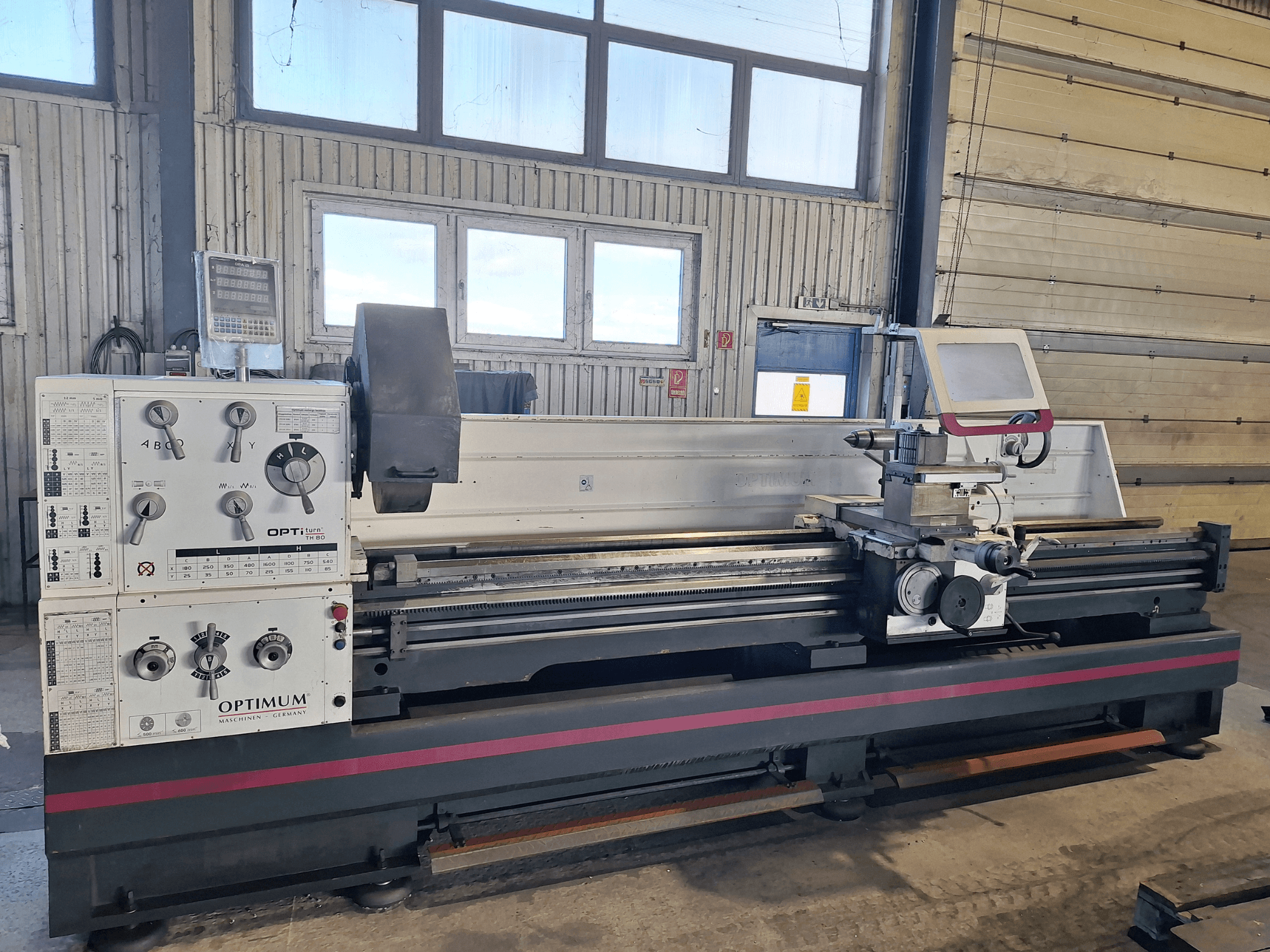 Tornos horizontales Optimum OptiTurn TH 8030D en vista lateral, con panel de control, portaherramientas y base robusta.