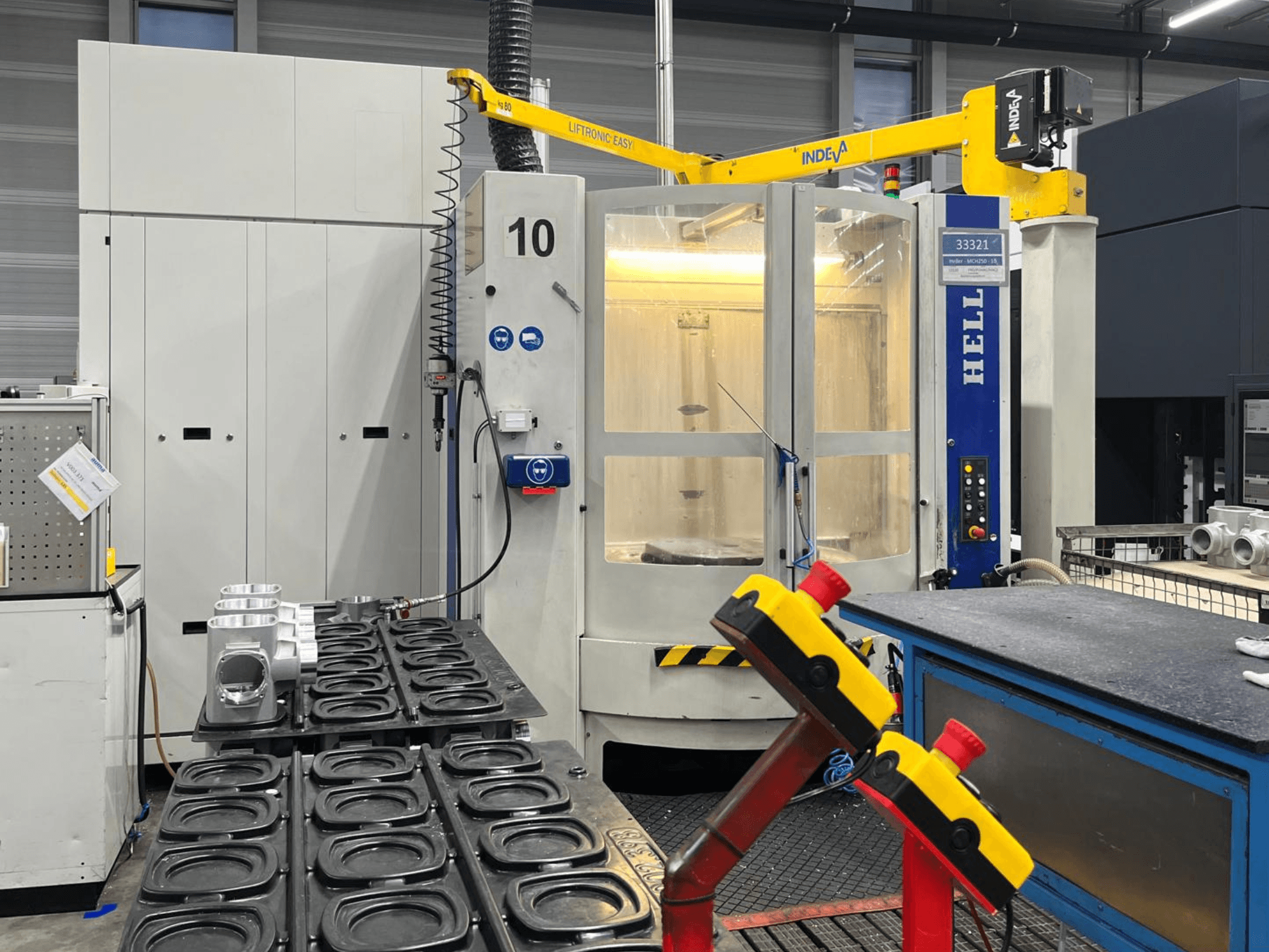 Centro de mecanizado horizontal HELLER MCH 250 en vista frontal, con piezas de aluminio y botones de control visibles en el lateral.