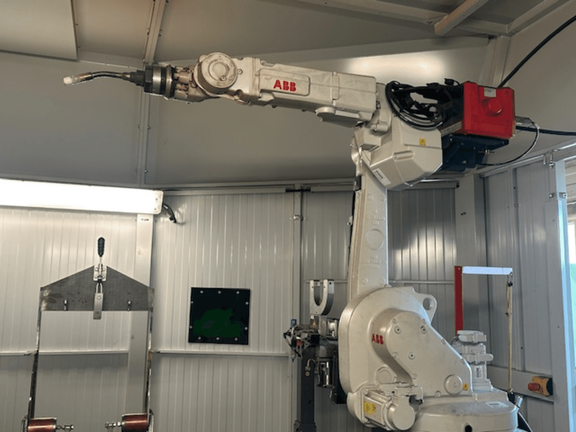 ABB Schweißroboter Flex Arc - vista lateral del brazo robótico con la herramienta de soldadura, mostrando detalles como el panel de control y los cables.