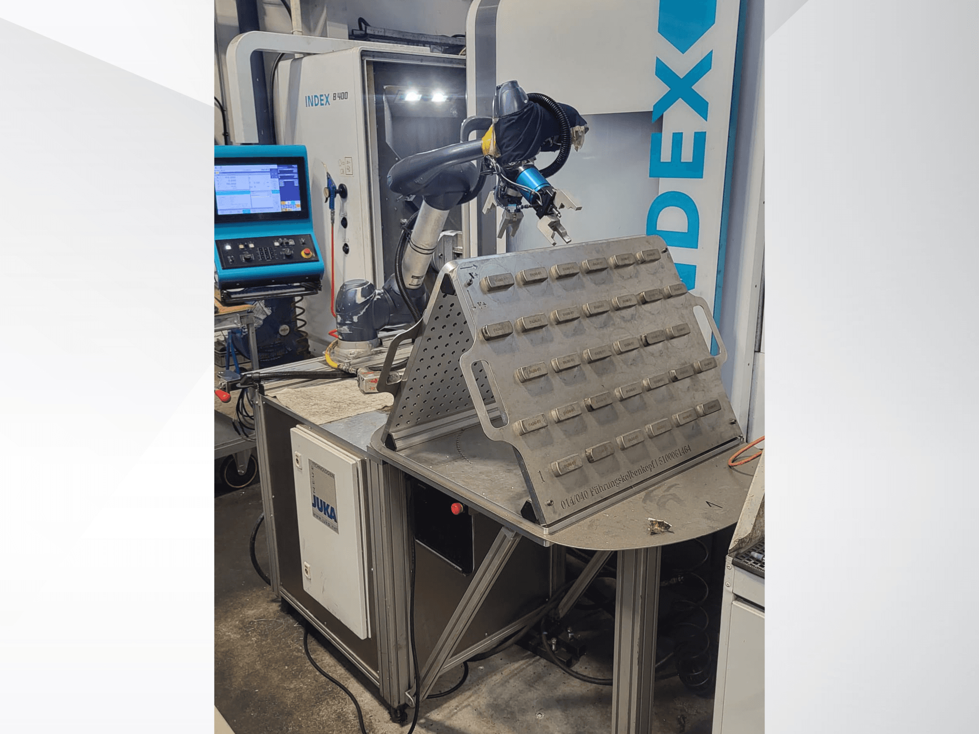 Robot colaborativo DOOSAN M1013 desde una vista frontal, colocado cerca de una mesa de trabajo con un portaherramientas y un panel de control.