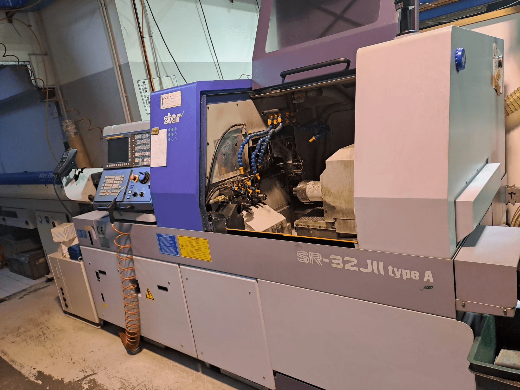 STAR MICRONICS SR-32JII-typeA Máquina de torneado tipo suizo vista lateral, con panel de control y componentes de mecanizado visibles.