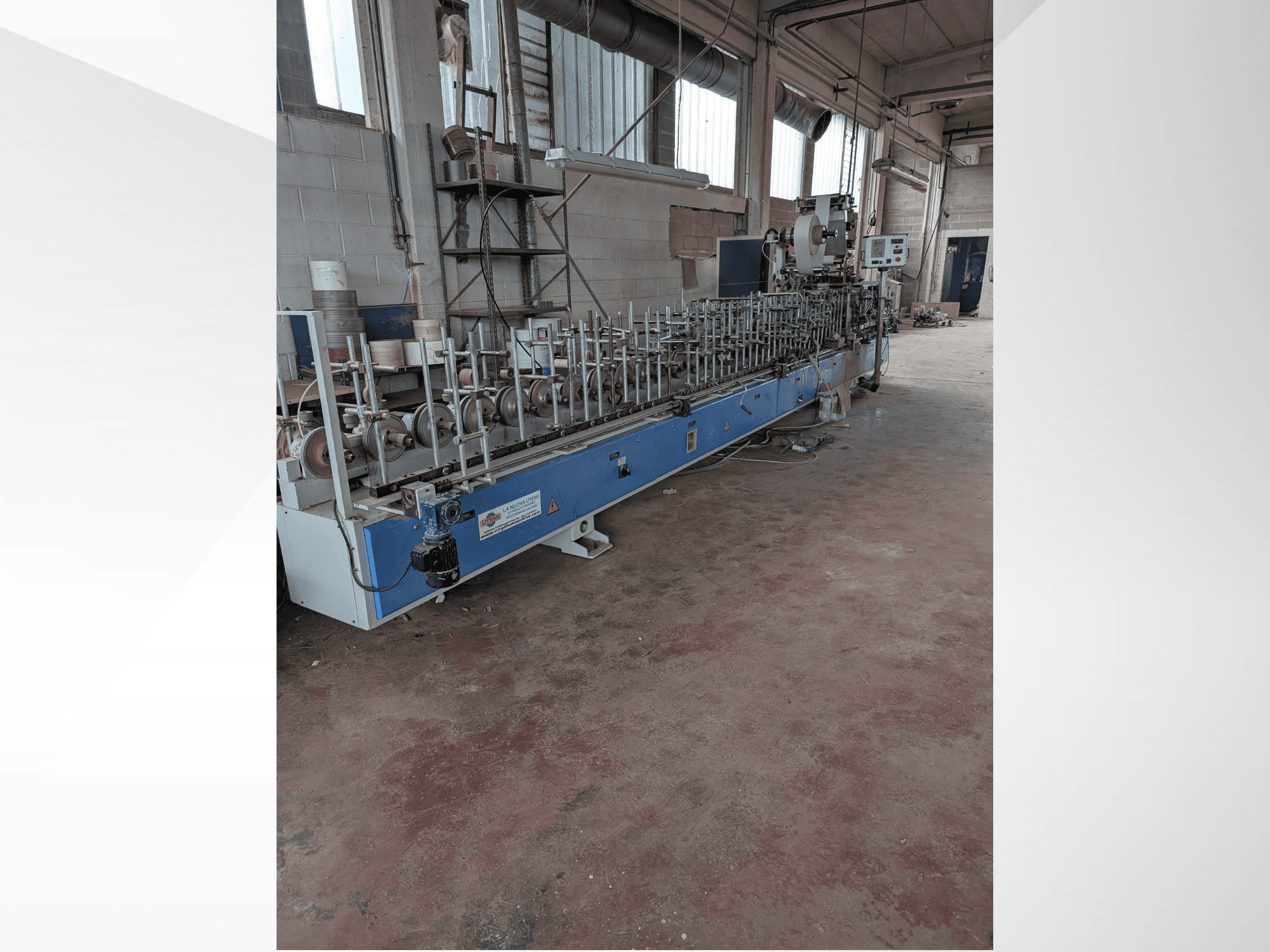 Vista frontal de una máquina PUR-33-L para madera, con múltiples husillos y un elegante diseño azul en un entorno industrial.