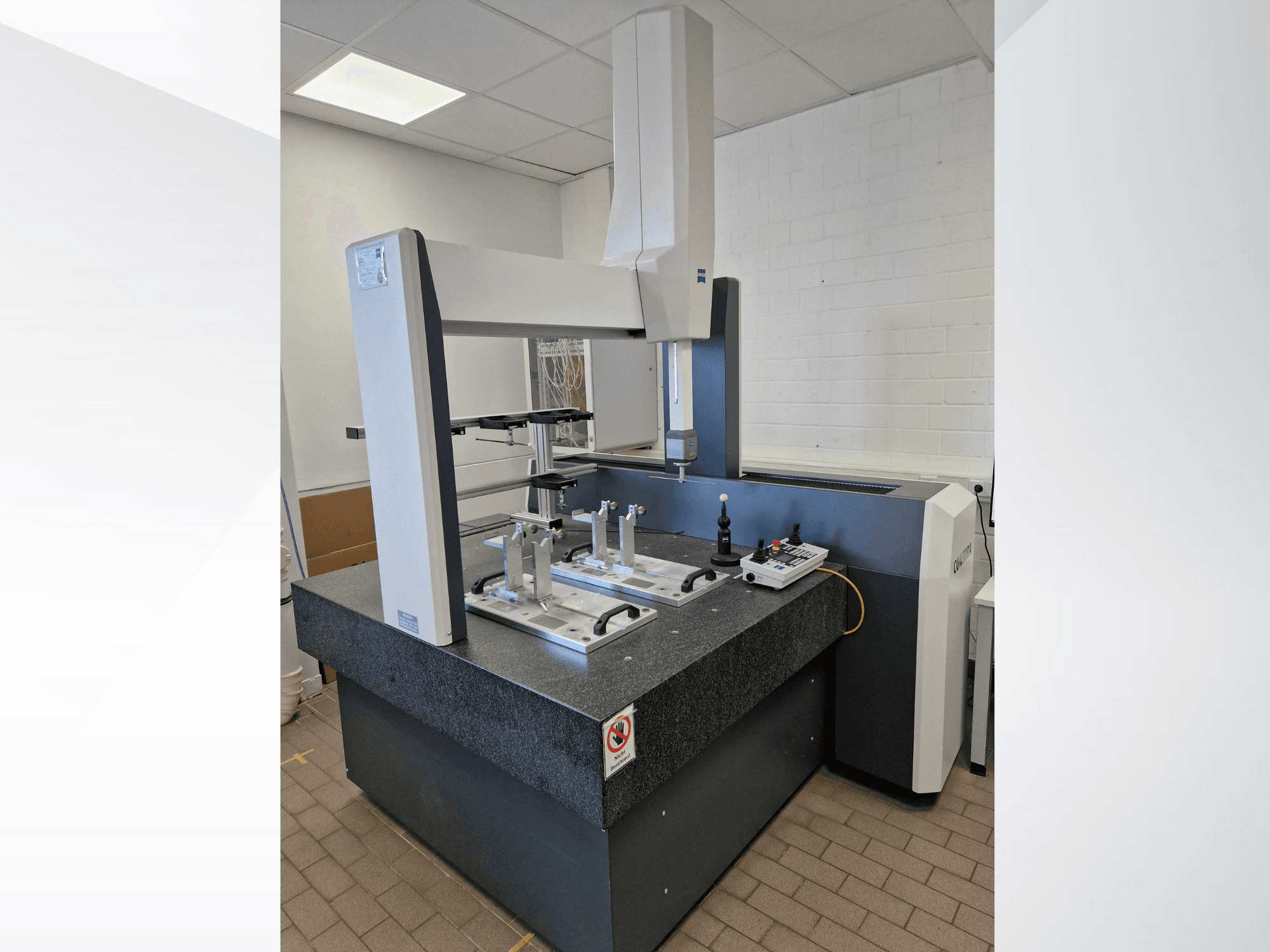 Zeiss coordinate measuring machine, front view, features a large granite surface, sensor arms, and control panel with buttons.