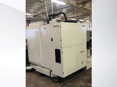 Máquina CNC industrial blanca vista de frente, con panel de control y ventilación, en un taller.