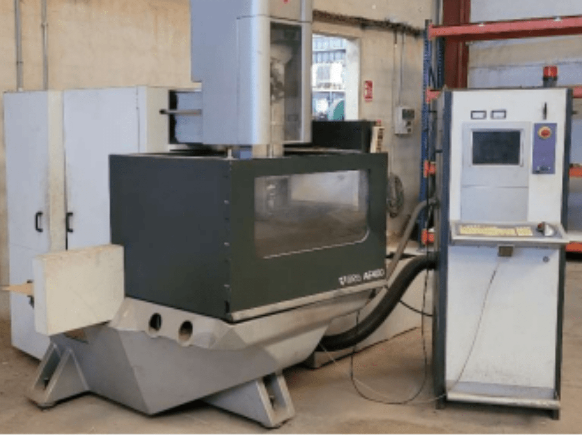 Máquina de electroerosión por hilo ONA AE 400 en un taller, con un panel de control a la derecha y una amplia zona de corte.