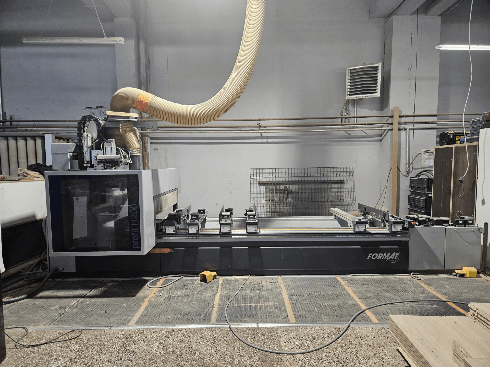 A FORMAT profit H200 CNC machine in a workshop, side view, showing the work surface and dust extraction system.