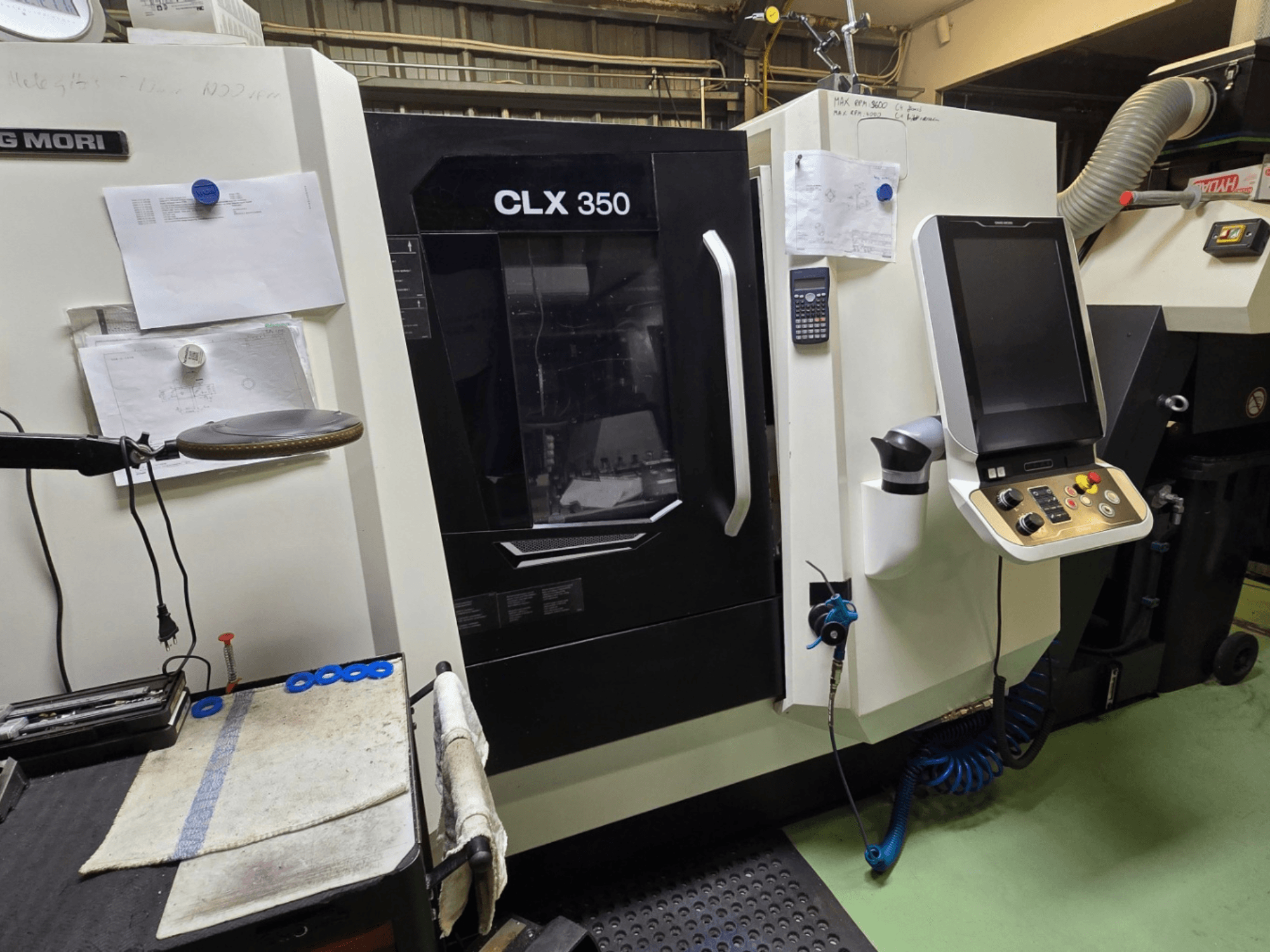 Torno CNC DMG MORI CLX 350 en un taller; vista frontal con panel de control, herramientas y espacio de trabajo visibles.