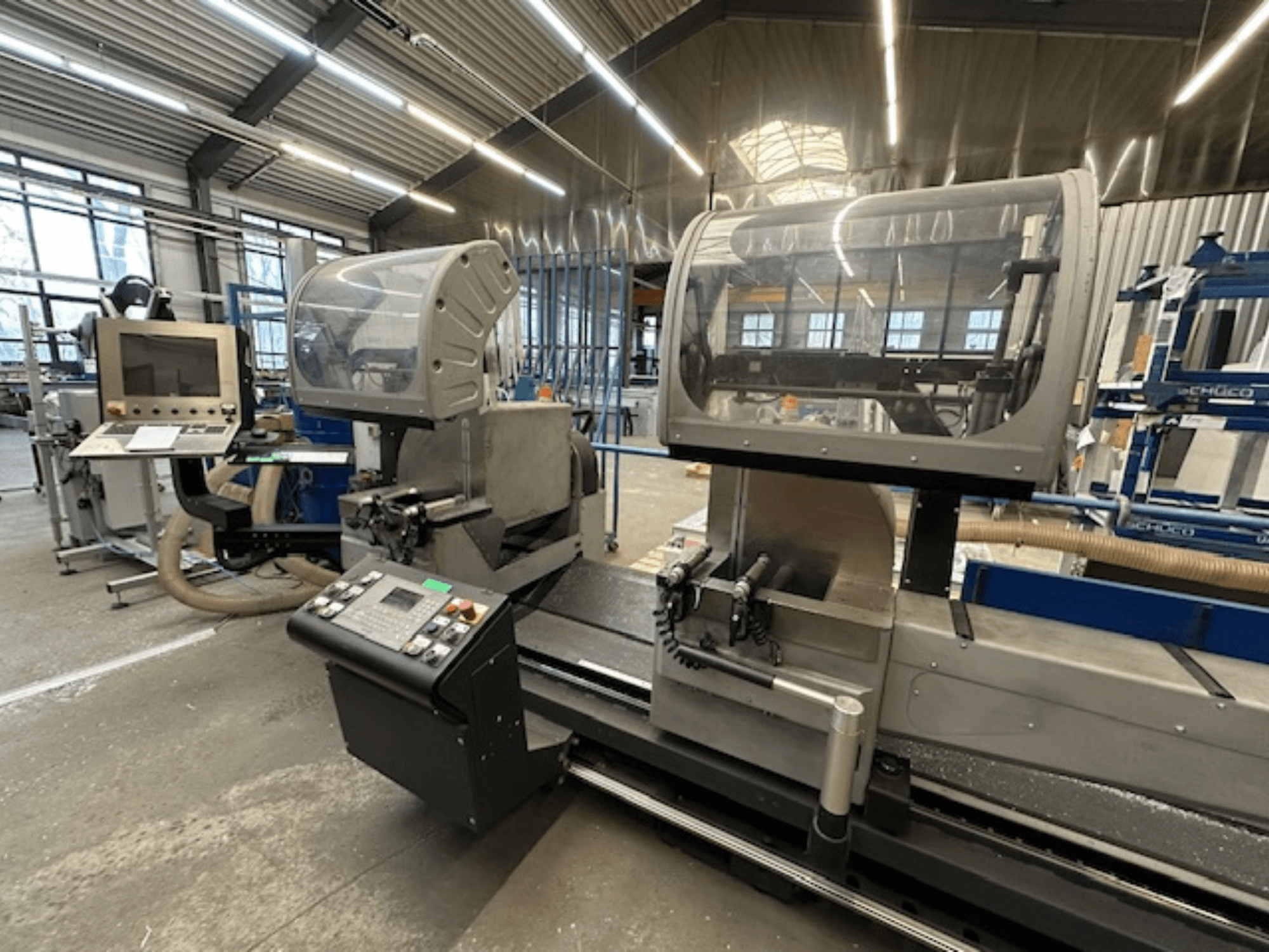 Sierra circular para metales SCHÜCO PDG E CUT, vista frontal, con panel de control, cubiertas protectoras y zona de corte en un taller.