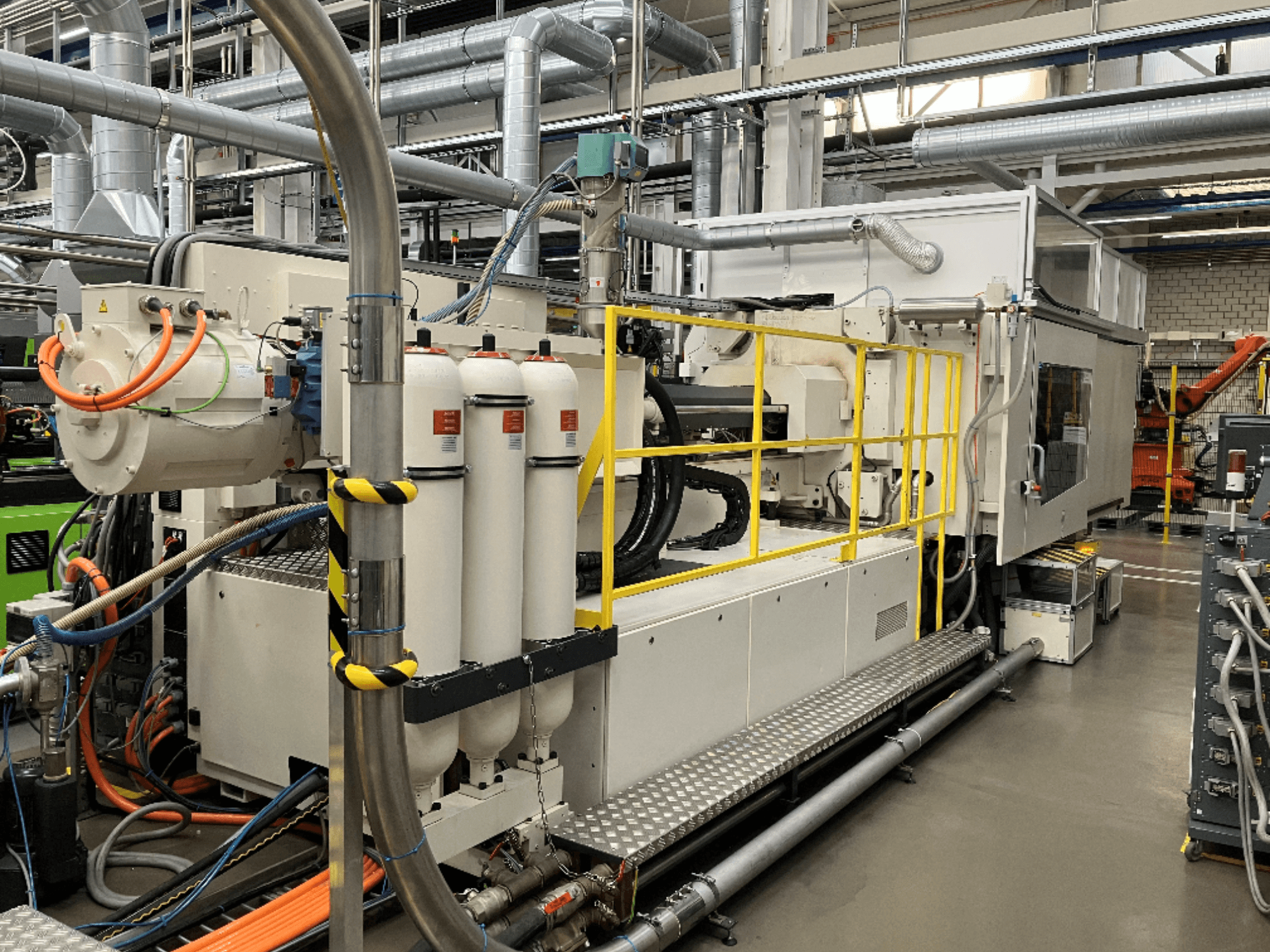 Máquina industrial con carcasa blanca y gris, múltiples mangueras y depósitos filtrantes; vista lateral que muestra la configuración operativa.