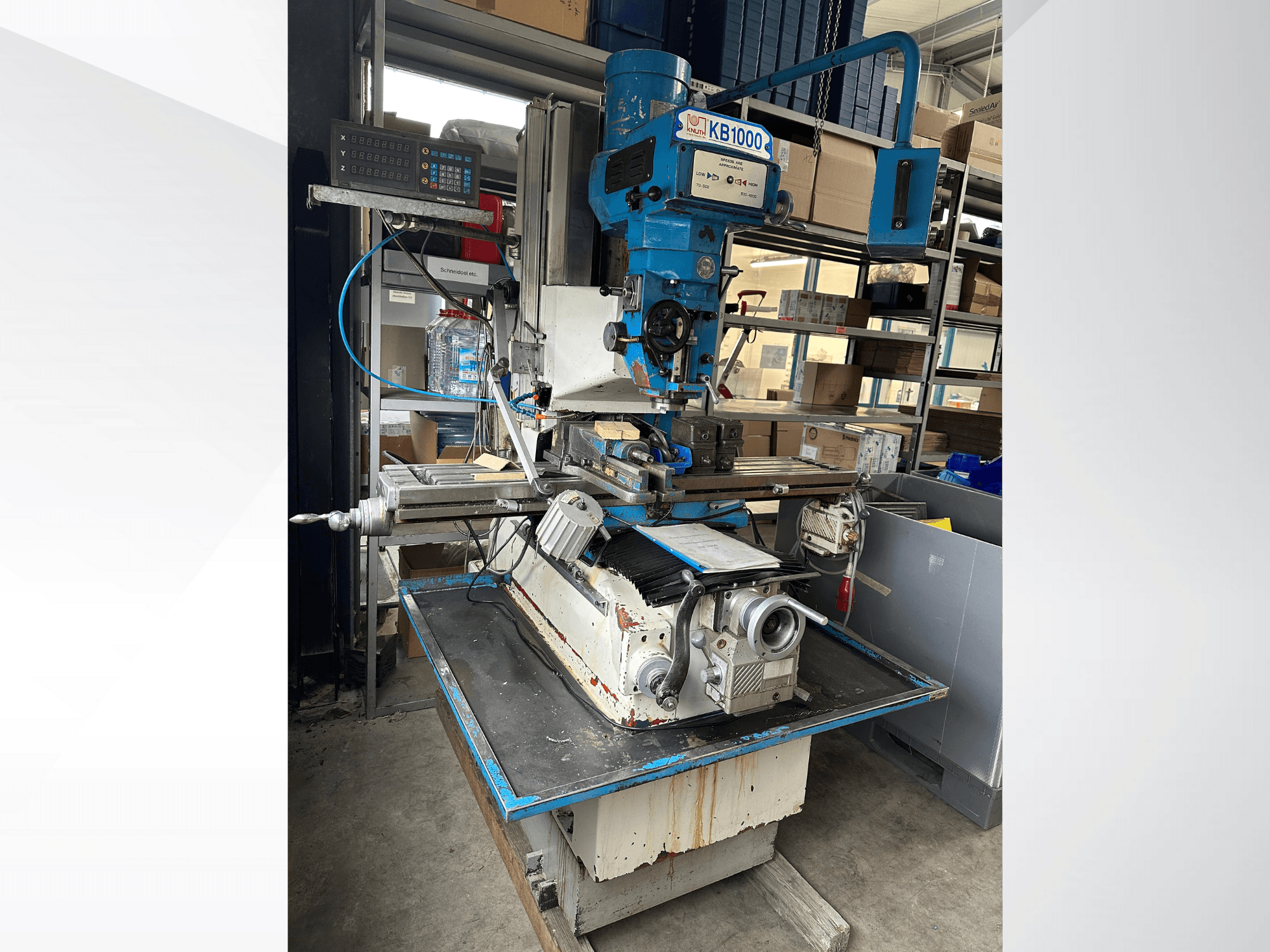 Fresadora vertical KB1000 con pantalla digital, vista lateral que muestra la mesa, el husillo y el portaherramientas.