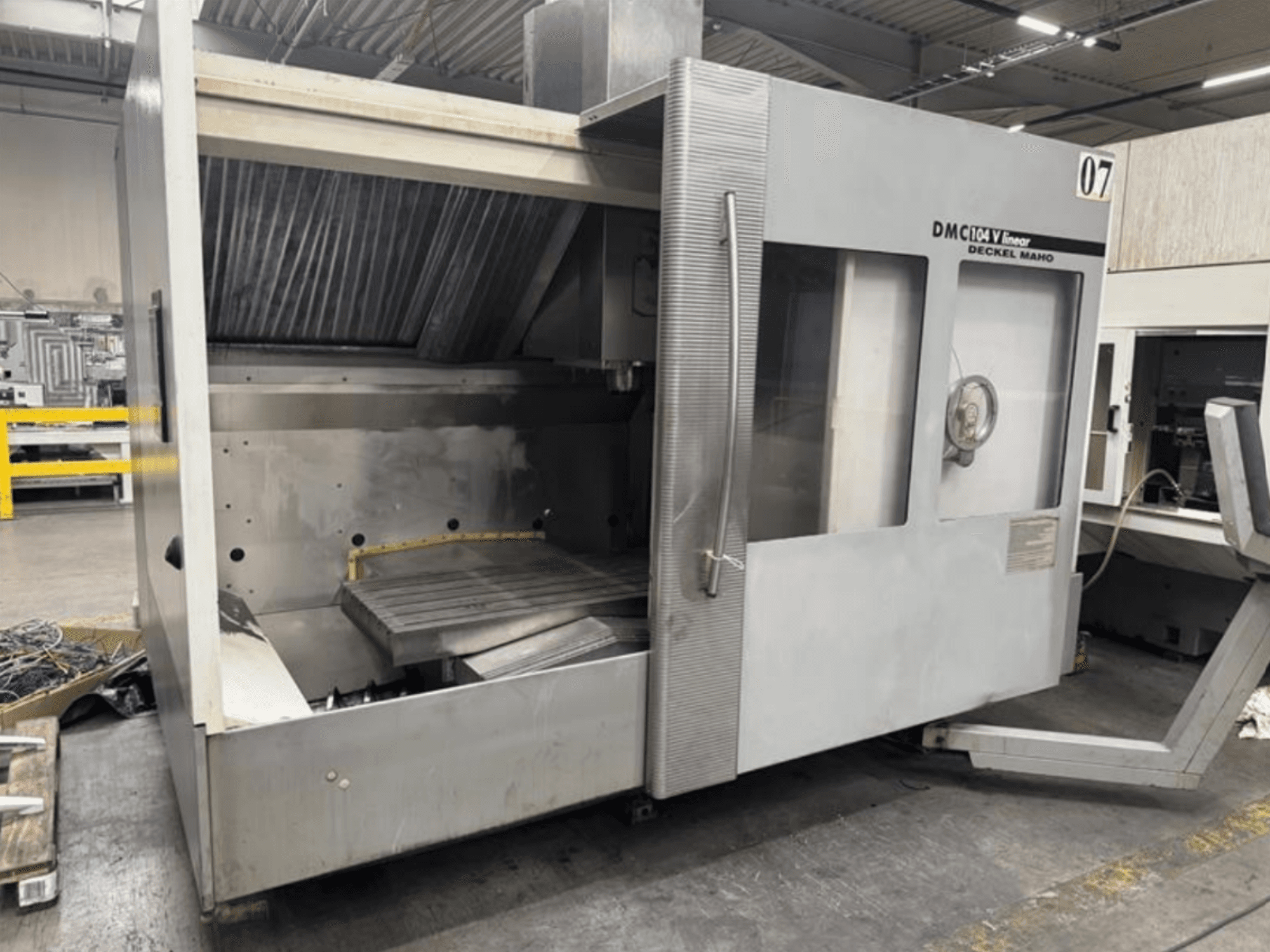 DMC 104 V linear machine by Deckel Maho, front view, featuring an empty machining area with a large work table.