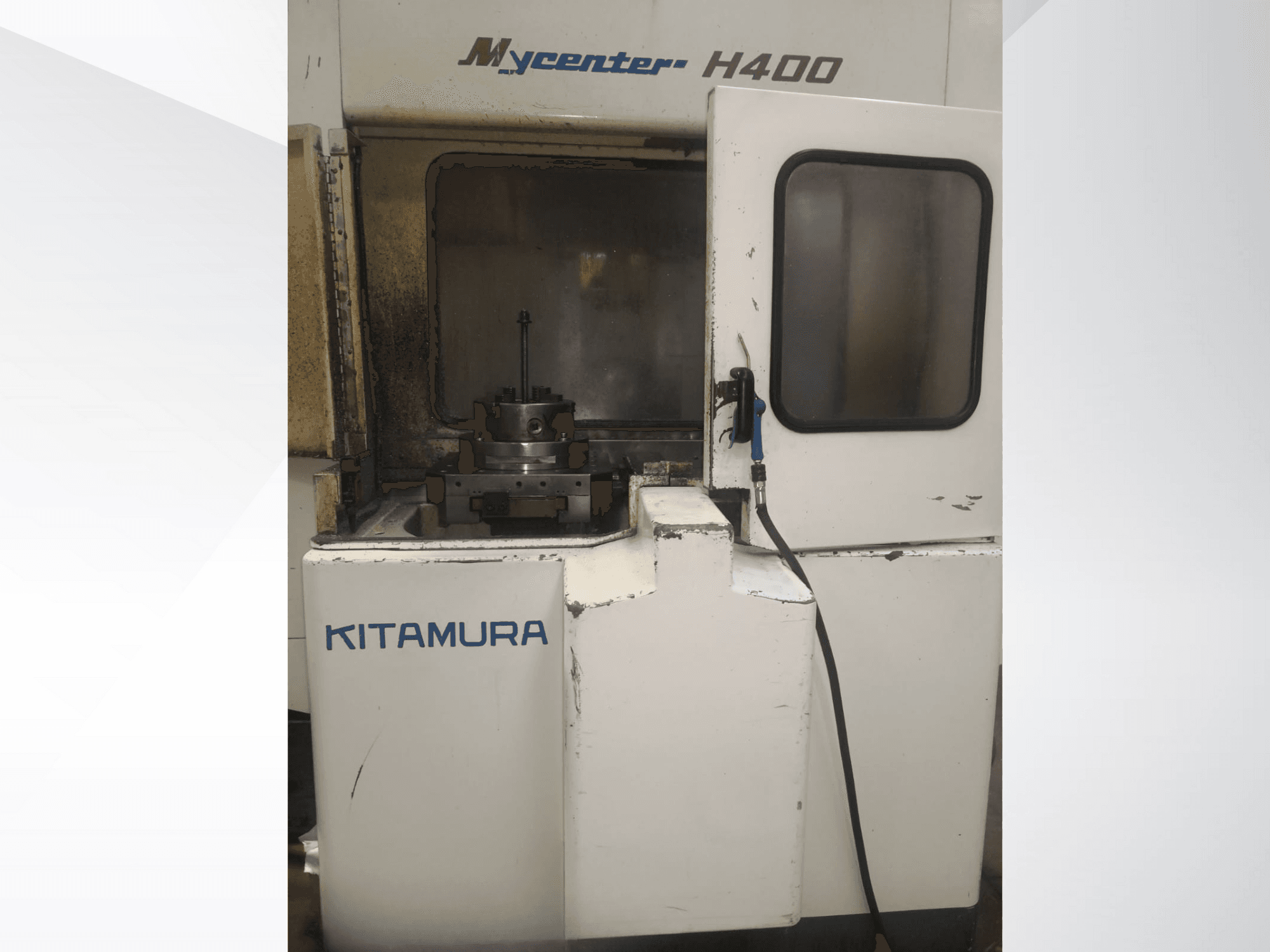 Máquina CNC Kitamura Mycenter H400, vista frontal, con área de trabajo visible y panel de control, mostrando signos de uso.